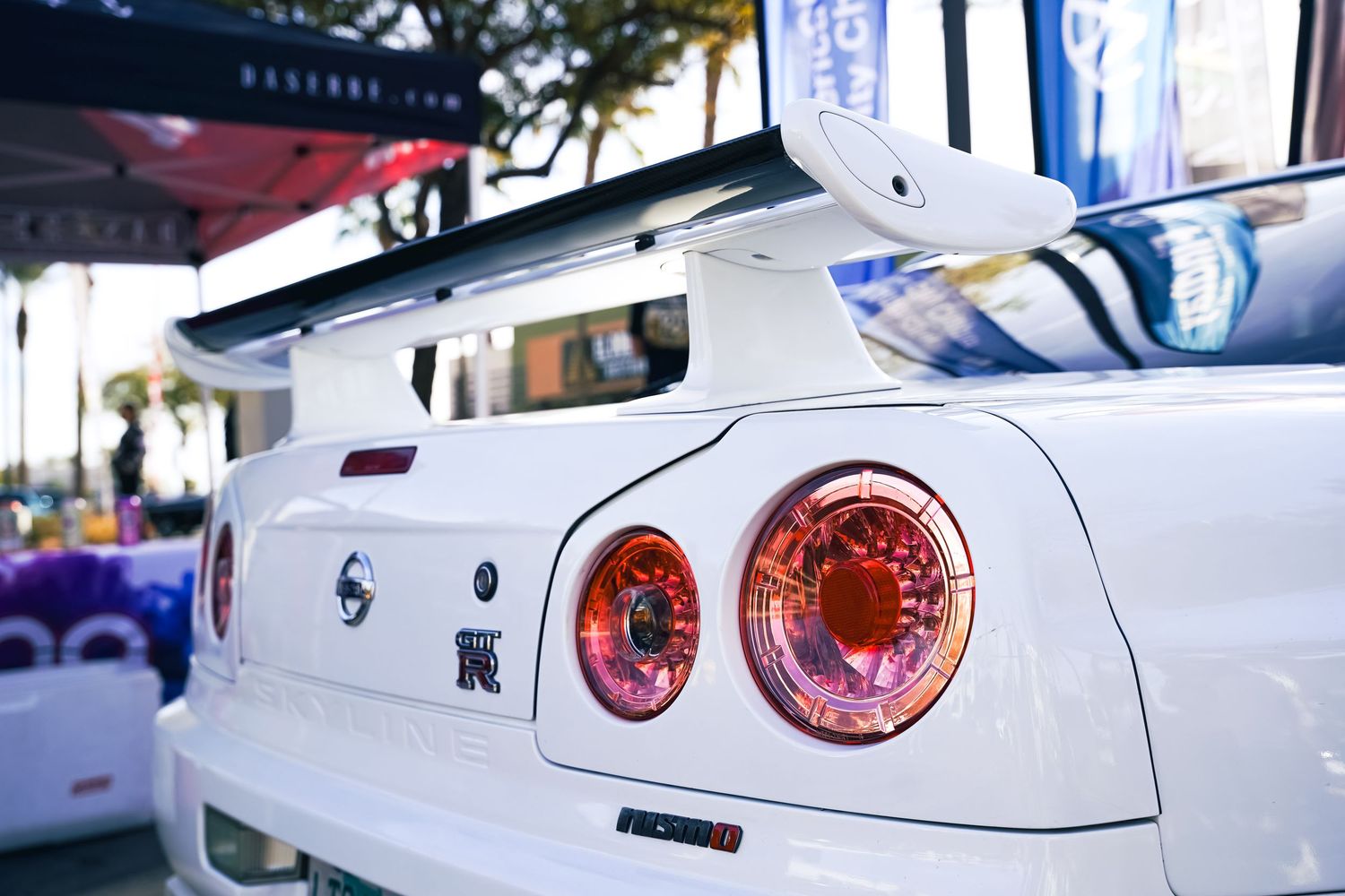 Close-up of white Nissan GTR rear tail lights with red illumination.