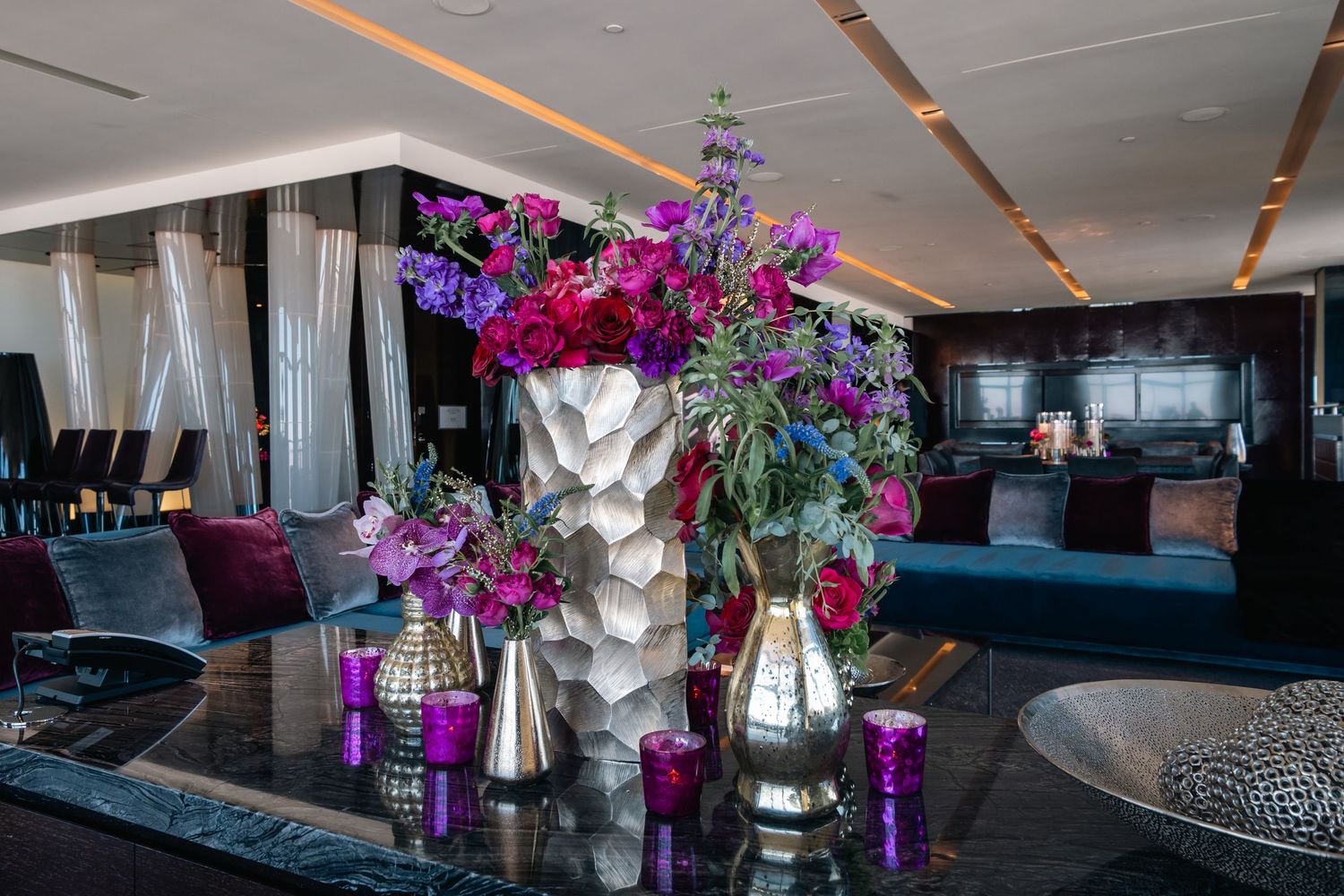 Luxury lounge area with purple floral arrangements and modern decor.