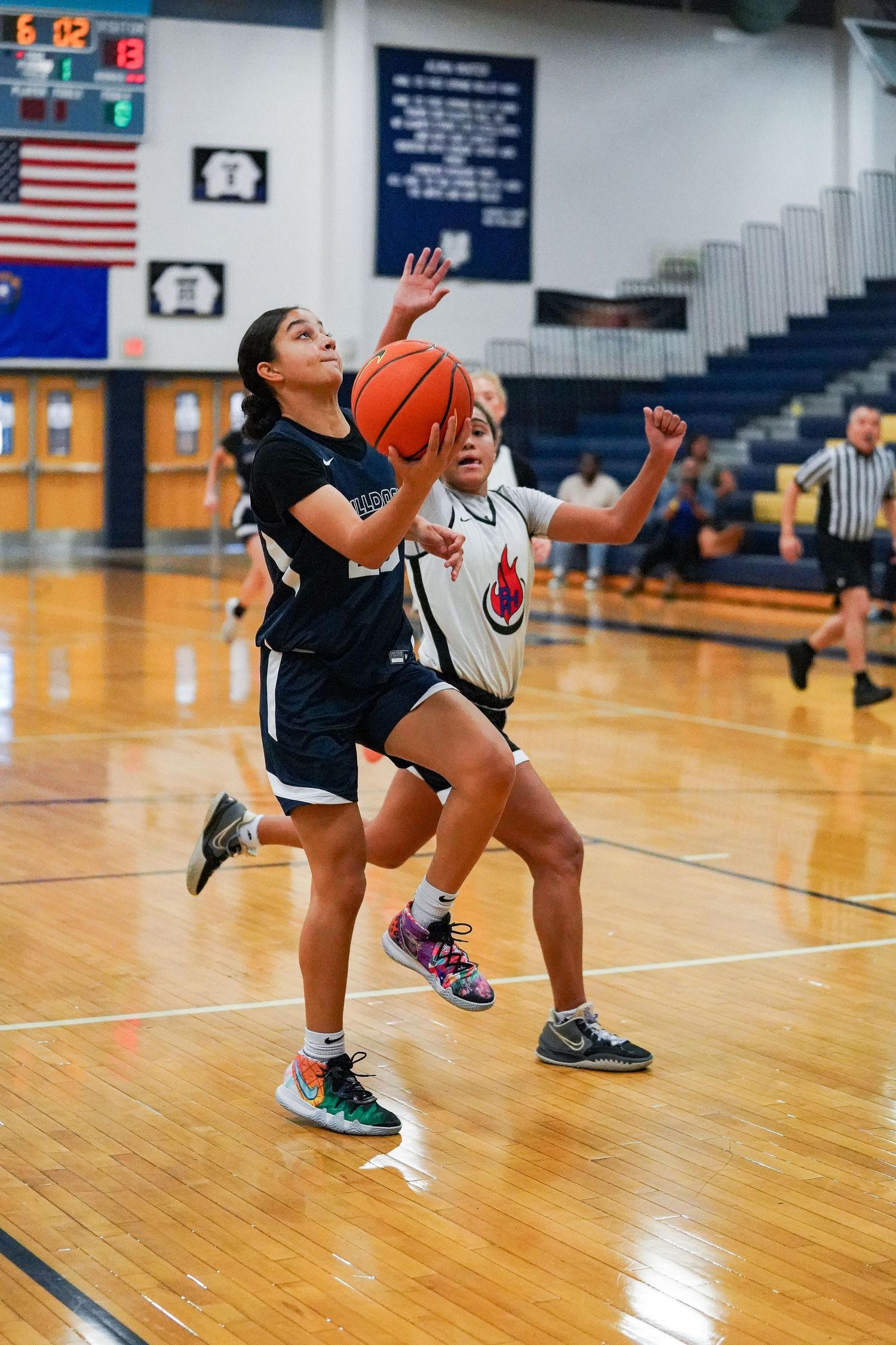 Basketball players execute defensive drills and shooting practice on the court.