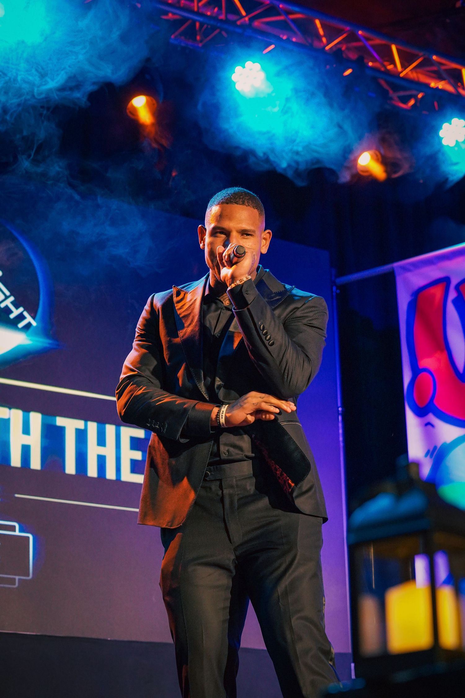 Stage performance with dramatic blue lighting and theatrical smoke effects.