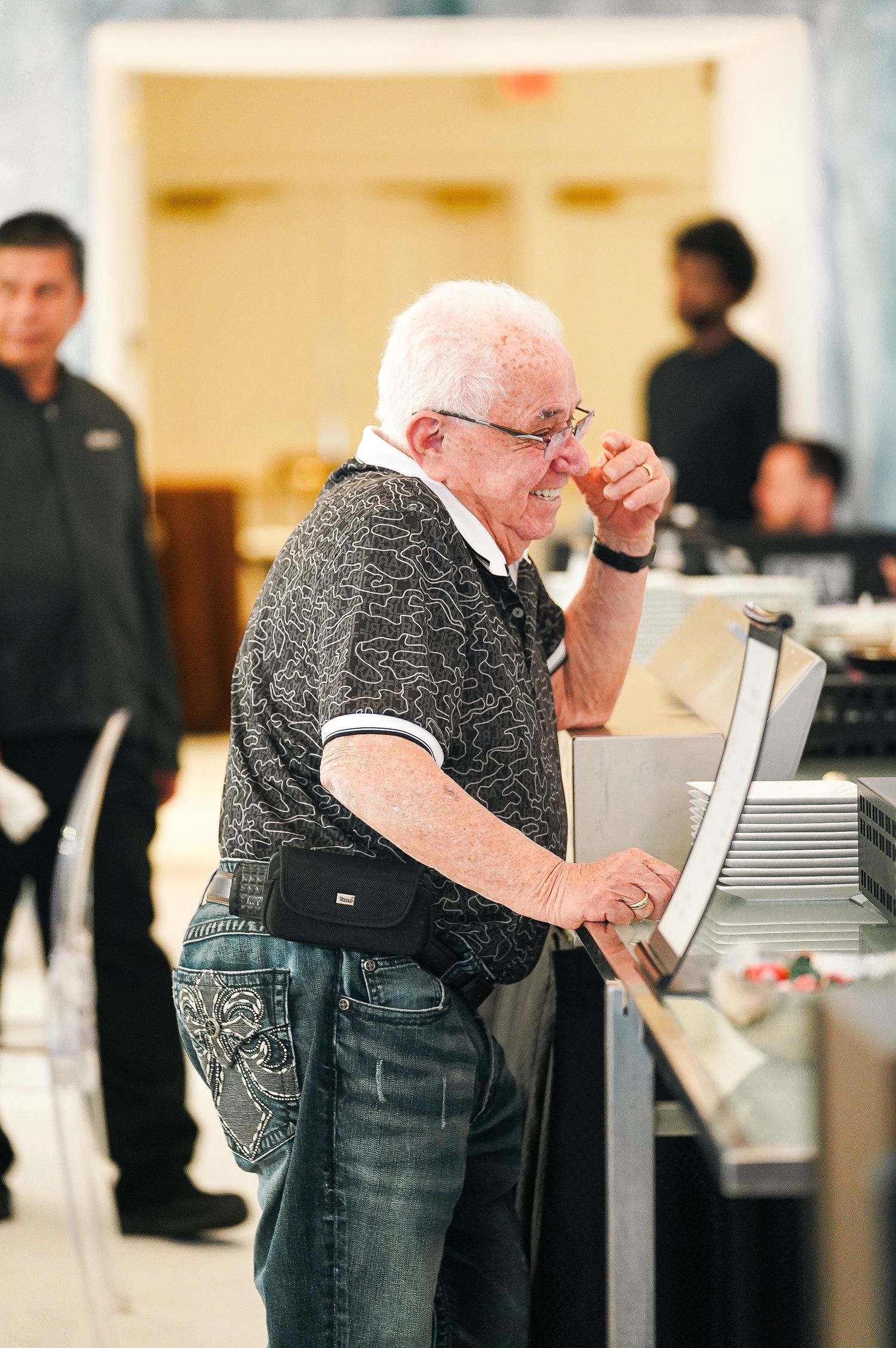 Senior person operating a register or computer terminal at an event.