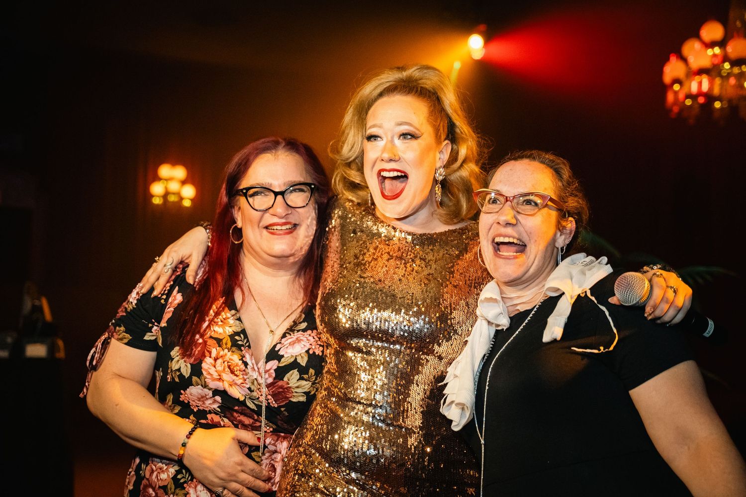 Three performers celebrating together at a cabaret show.