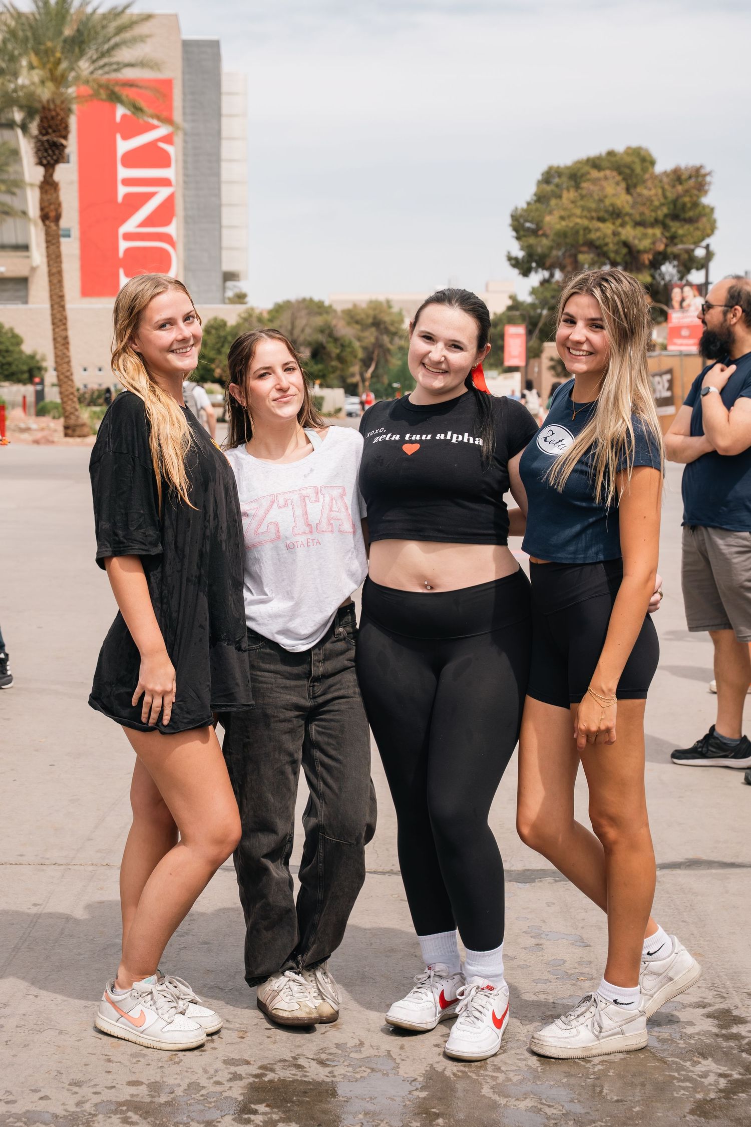 Group of students pose together at a campus event with UNLV signage visible in background.