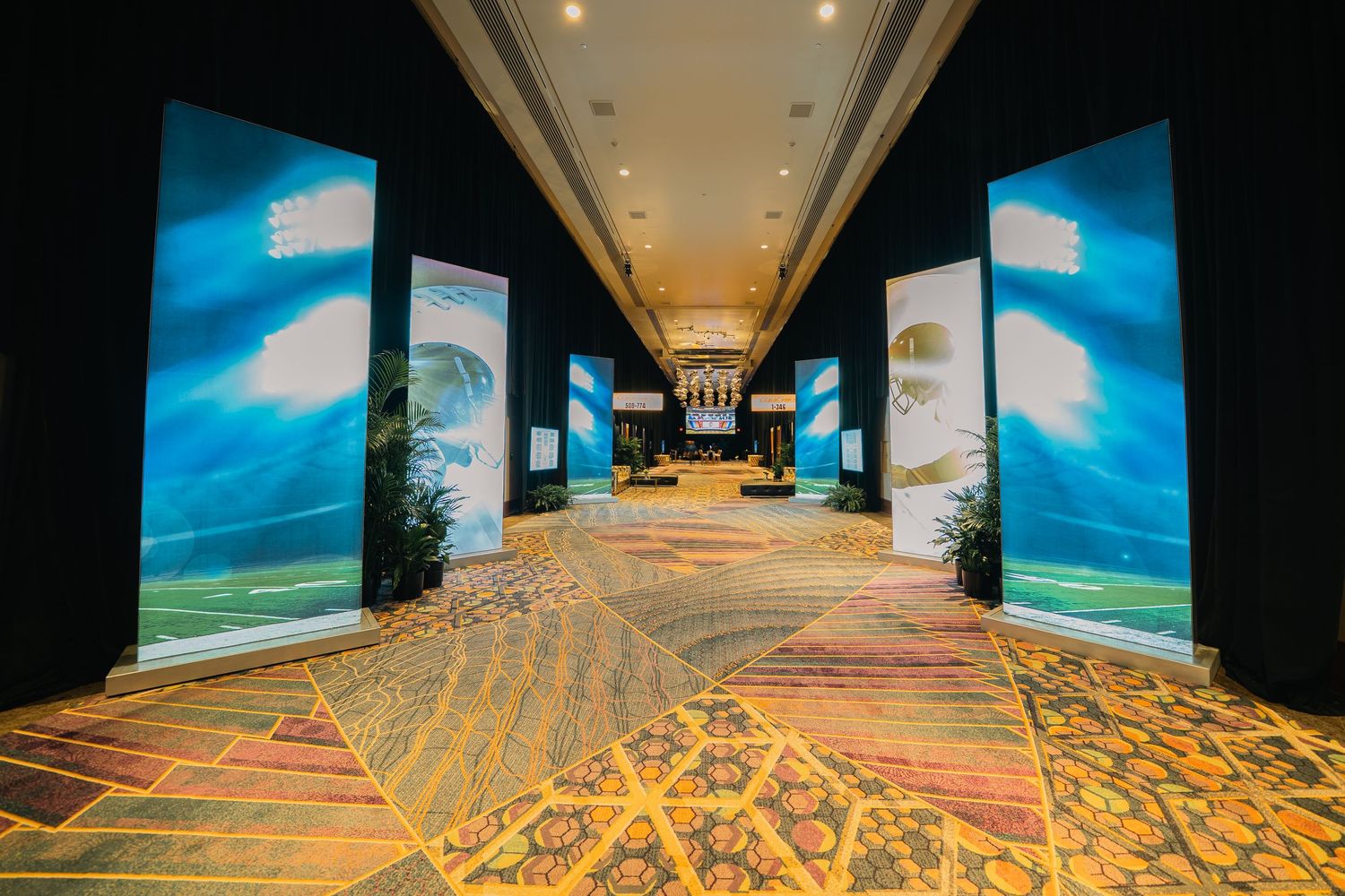 Modern casino corridor with blue accent walls and intricate geometric carpet patterns.