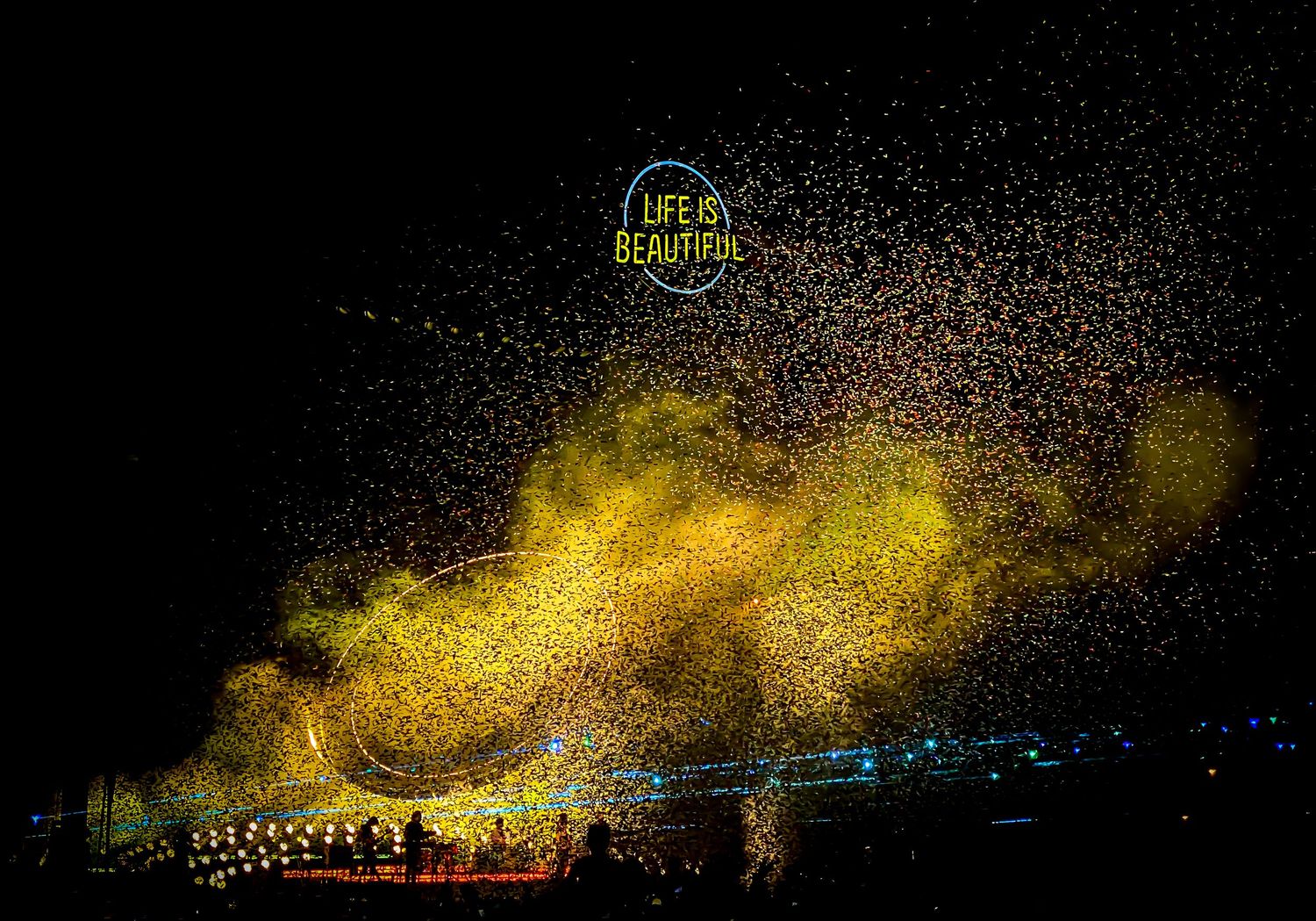 Golden fireworks display illuminates night sky with bright sparks and light trails.