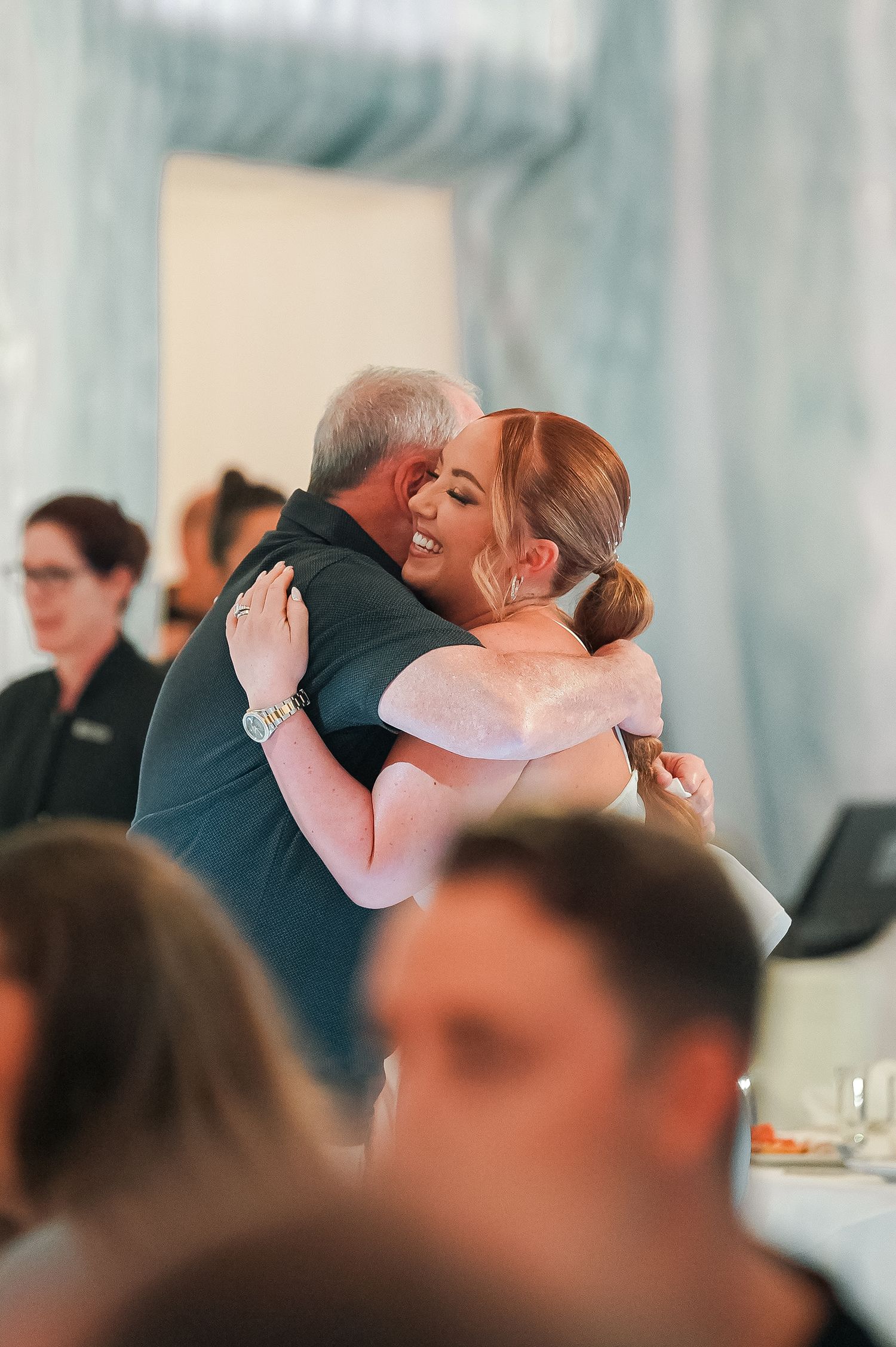 Emotional embrace between two people during a formal celebration.