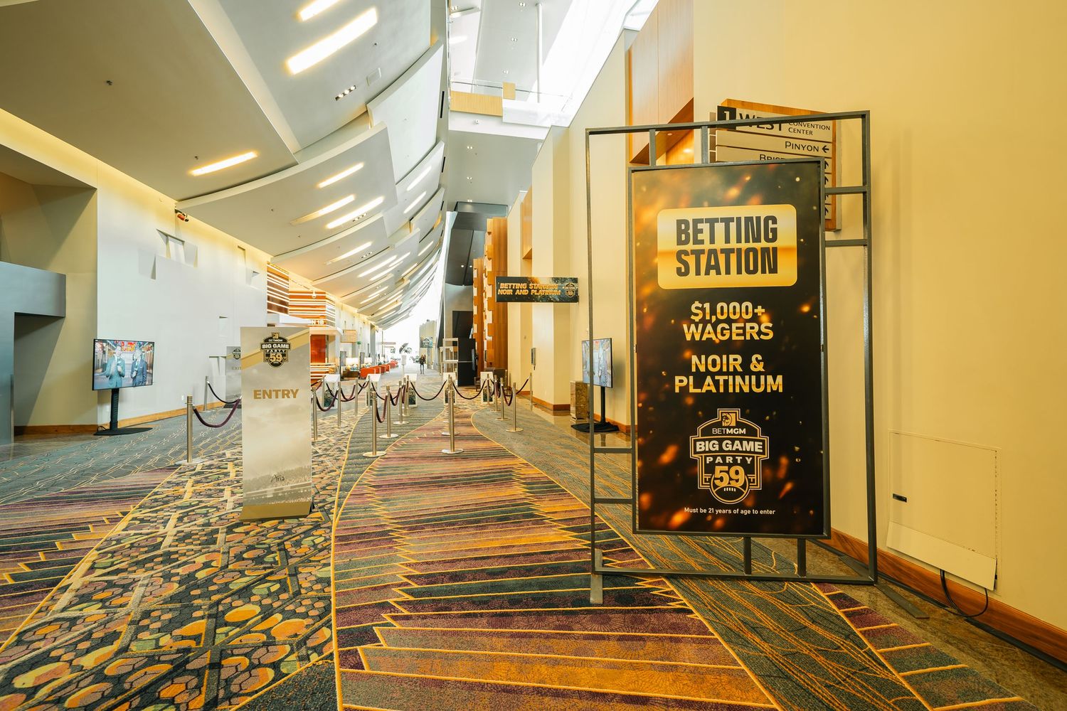 Corporate hallway with betting station signage and patterned carpet.