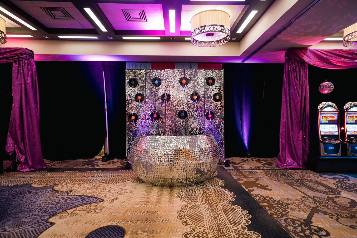 Glittering disco ball display with purple lighting and slot machines visible.