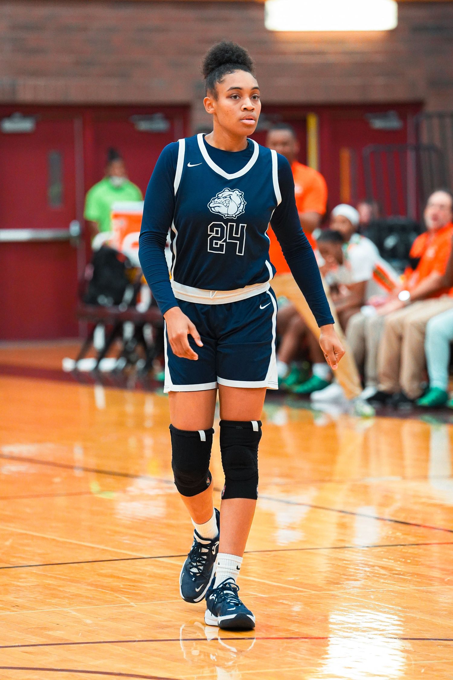 Players in navy blue uniforms move across a shiny basketball court during a game.