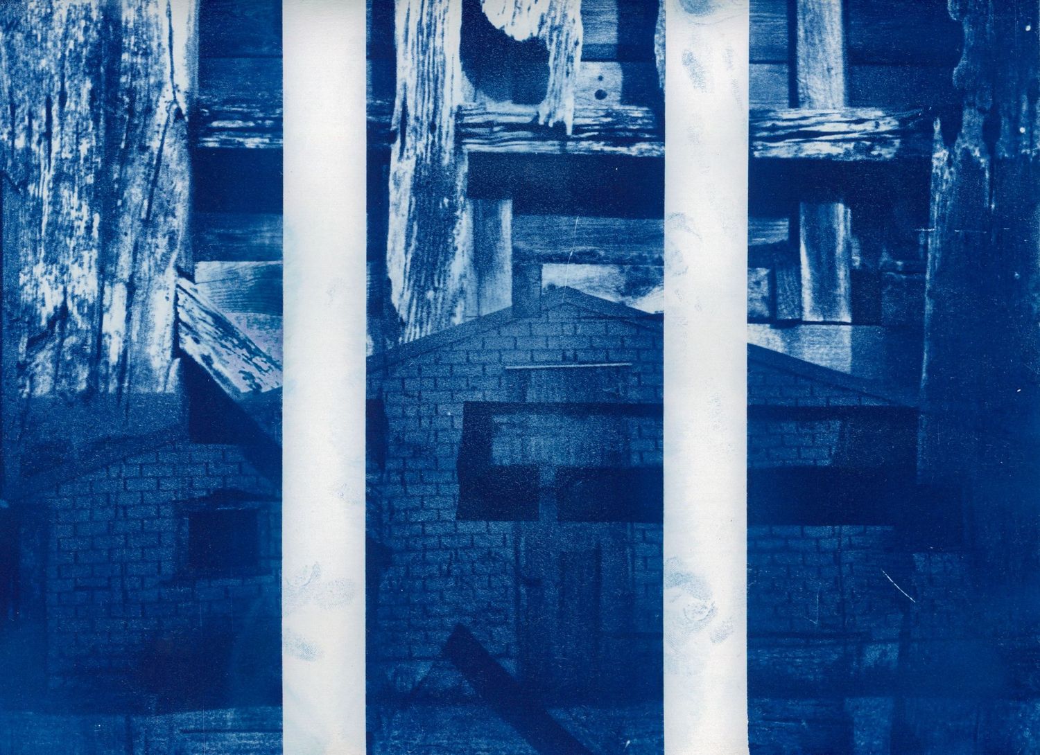 Abstract architectural photograph in blue showing columns and brick structures.