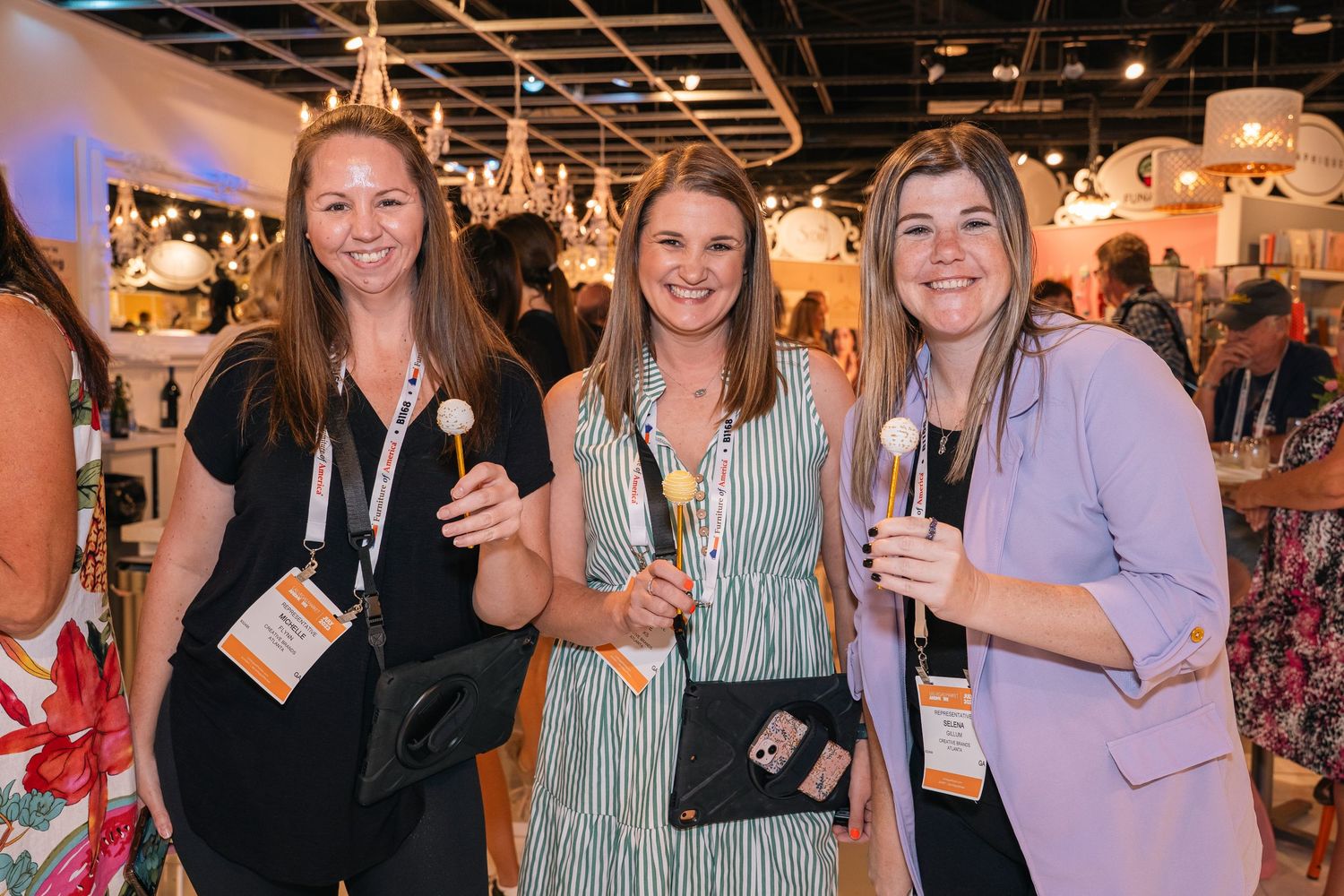 Three colleagues in business attire pose together at a retail industry event.