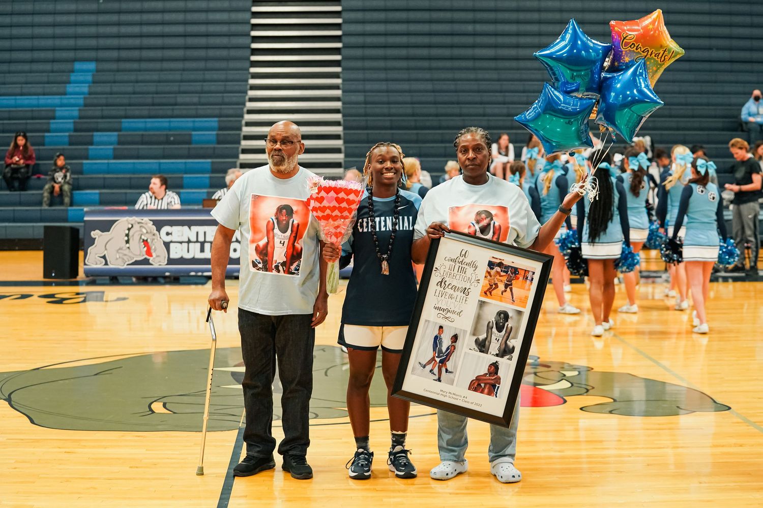 Basketball gymnasium with star balloons and players during a special event.
