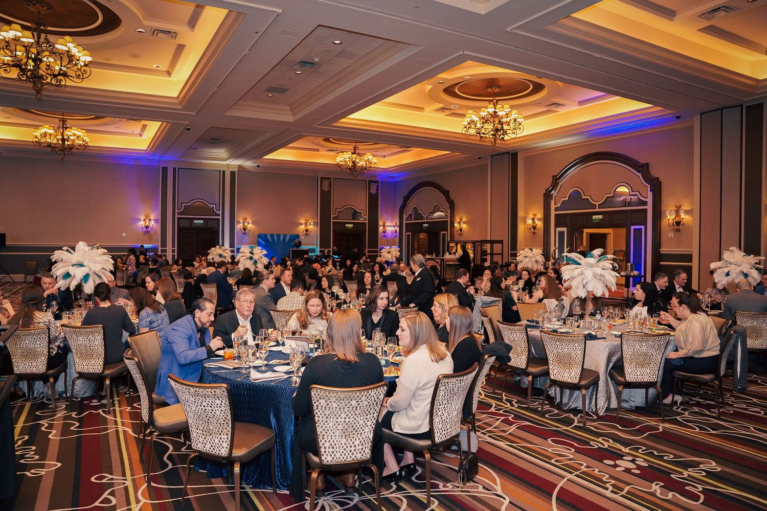 Large formal ballroom setup with round tables and elegant lighting for awards ceremony dinner.