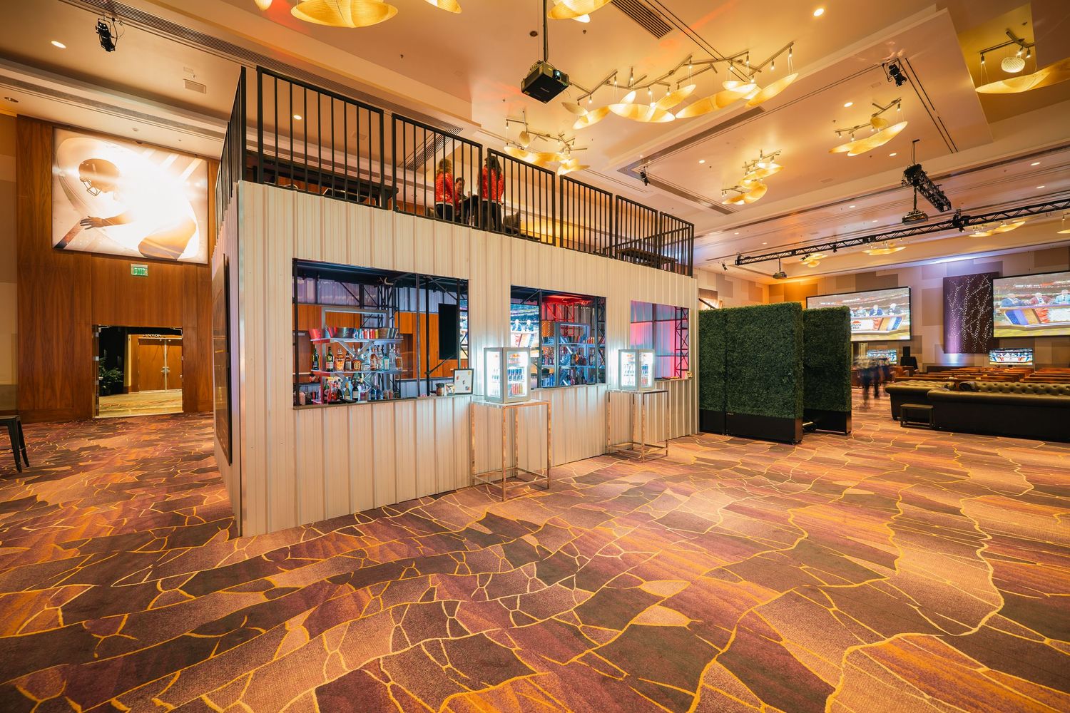 Expansive casino interior with patterned carpeting and distinctive architectural lighting fixtures.