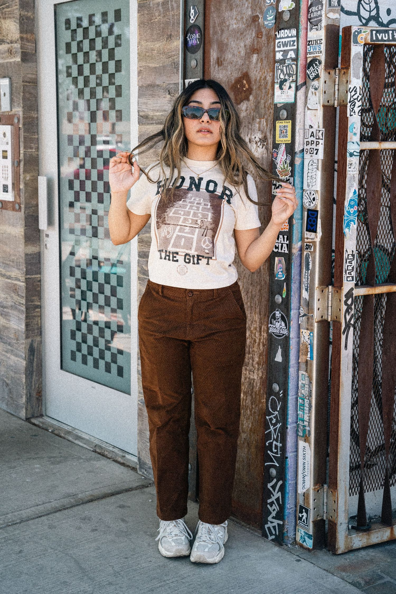 Street fashion series featuring casual outfit against industrial doorway with checkered pattern.