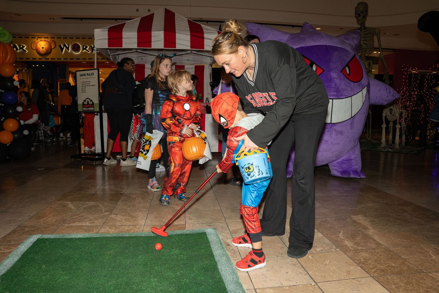 Halloween mini golf activity with costumed participants at a mall event.