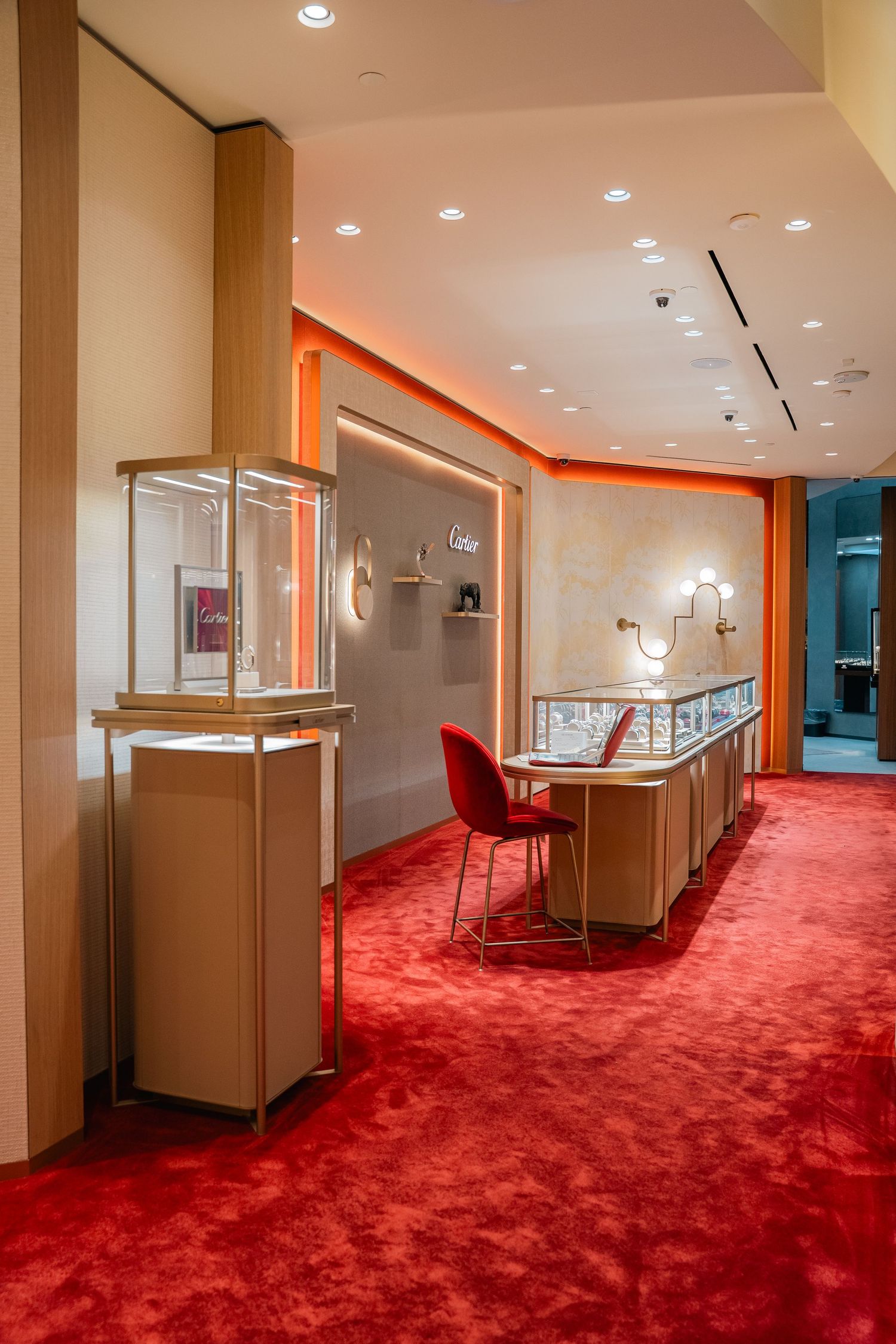 Luxury jewelry store interior with red carpet and glass display cases.
