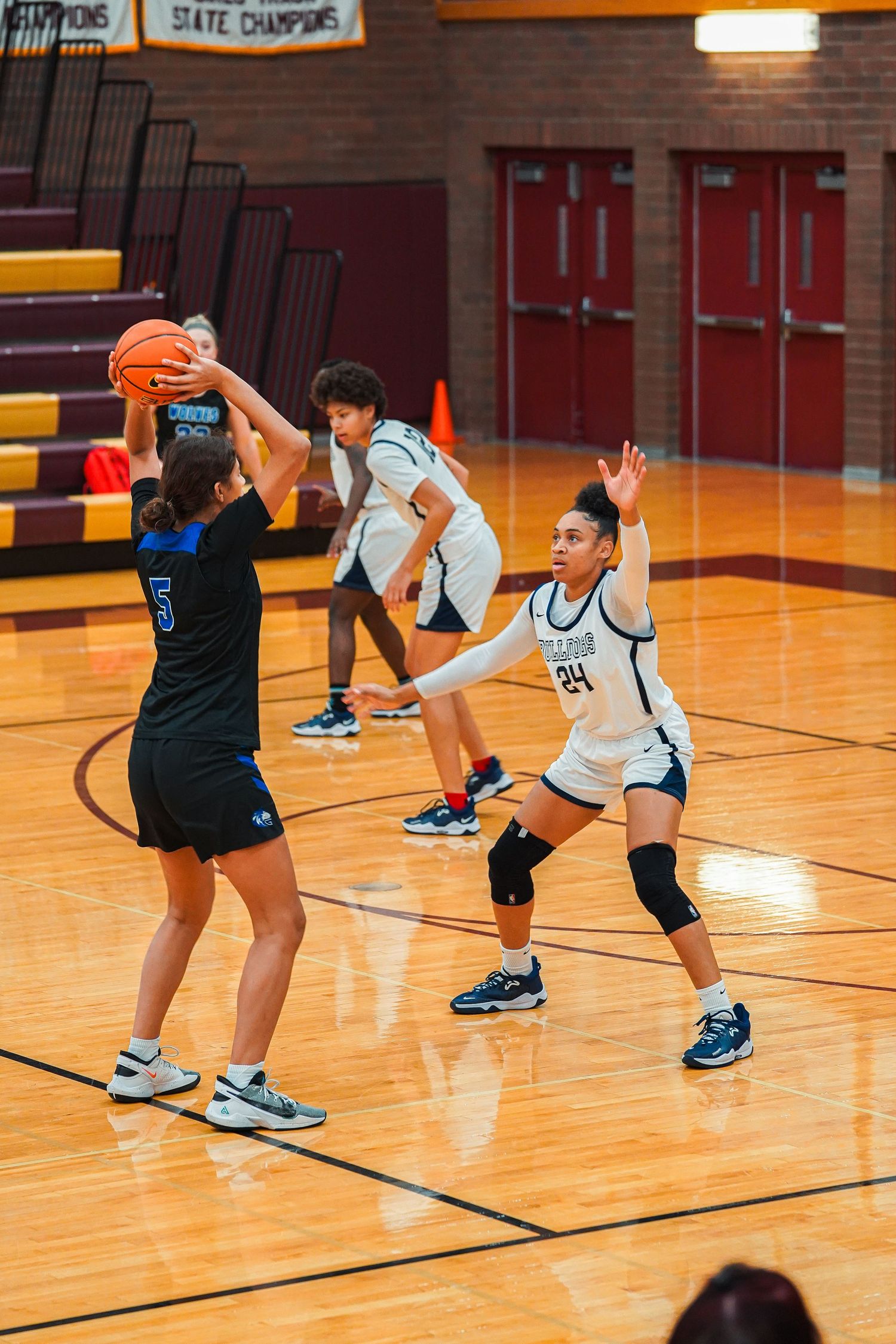 Basketball players practice defensive moves and footwork drills on the hardwood court.