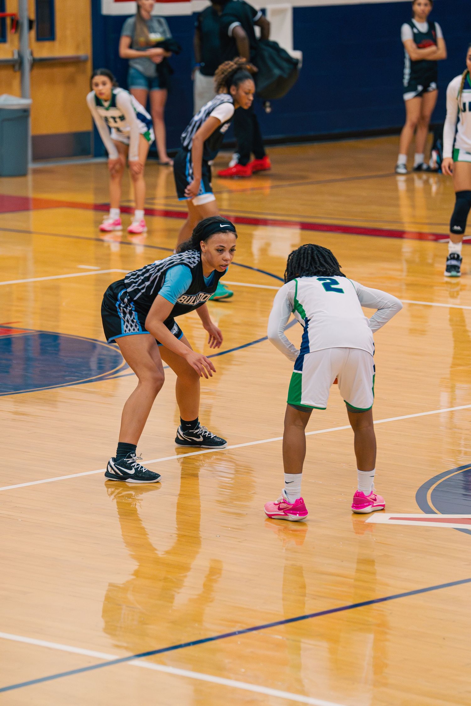 Two players in defensive stance during competitive basketball game.