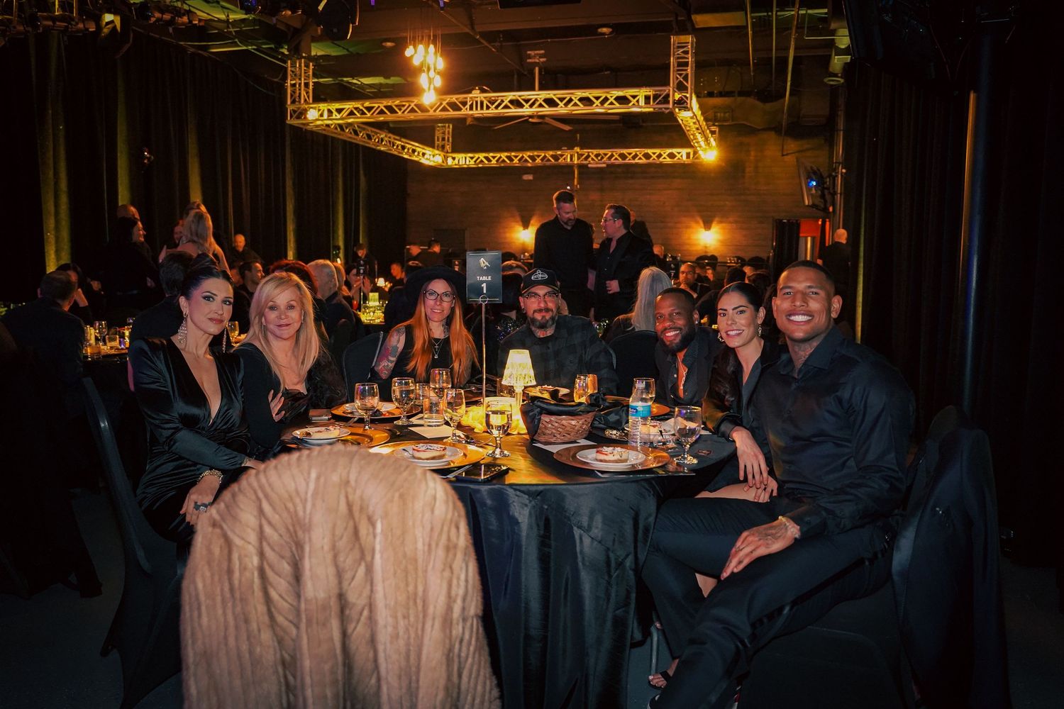 Dark atmospheric dining room setup with multiple tables and ambient lighting.