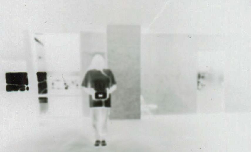 Blurry black and white photograph of figure in empty space.