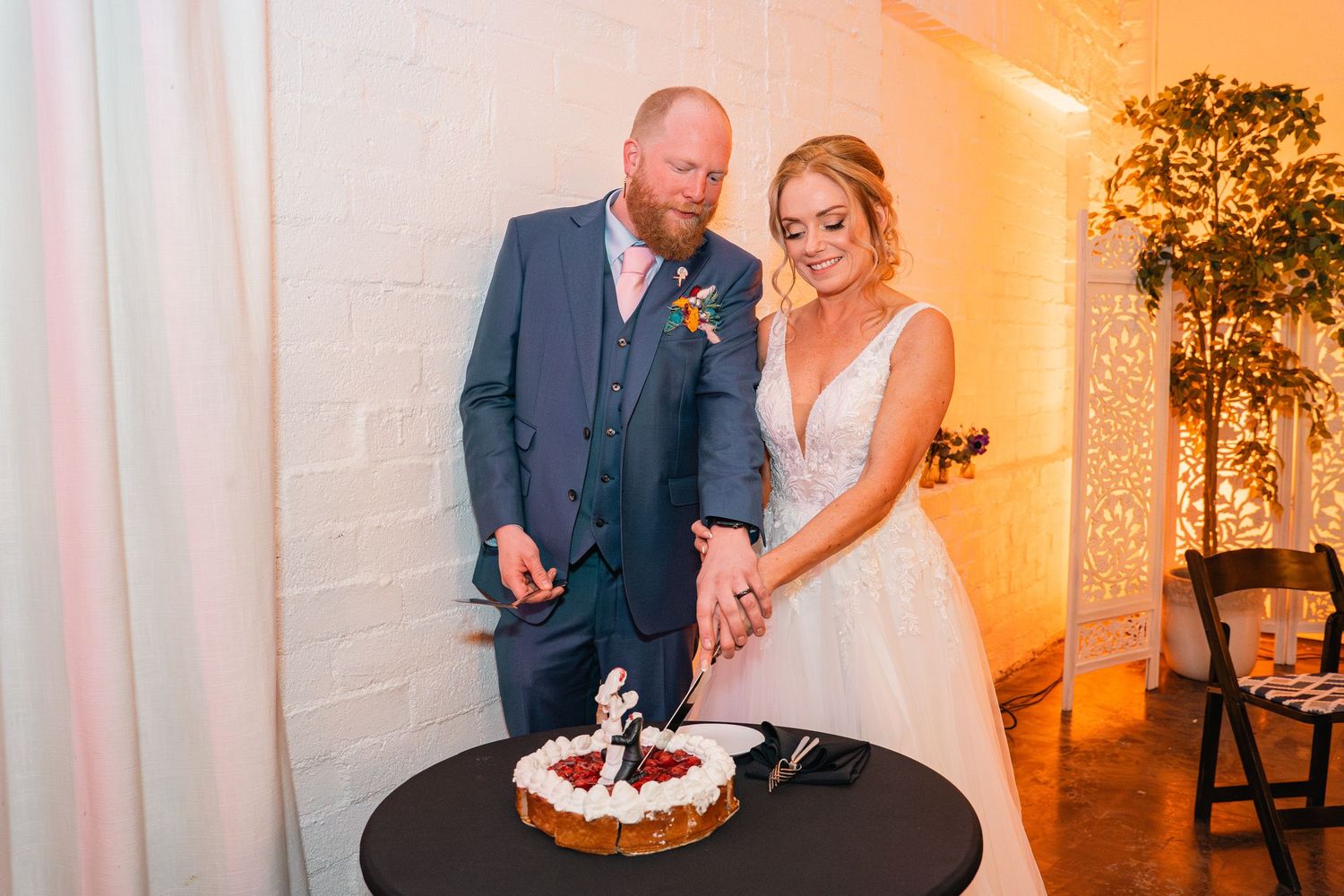 Couple shares intimate moment while cutting their wedding cake at reception.
