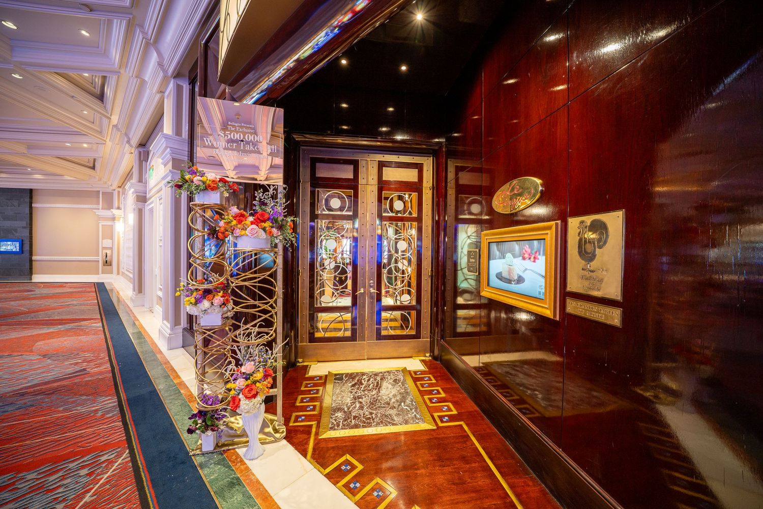 Decorative hallway with Asian-inspired artwork and displays featuring rich red walls and patterned carpeting.