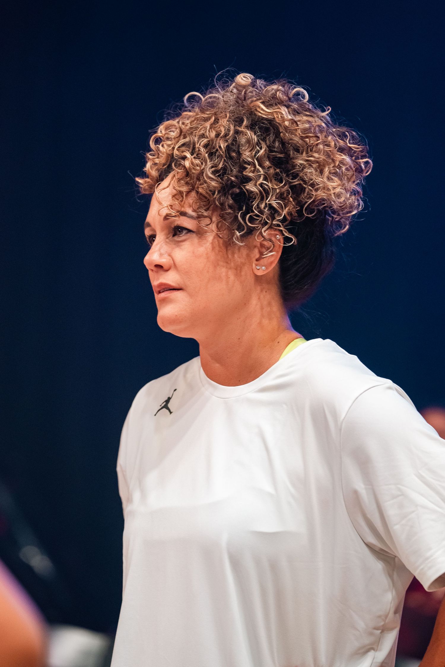 Portrait of athlete in white Jordan t-shirt during indoor basketball practice.