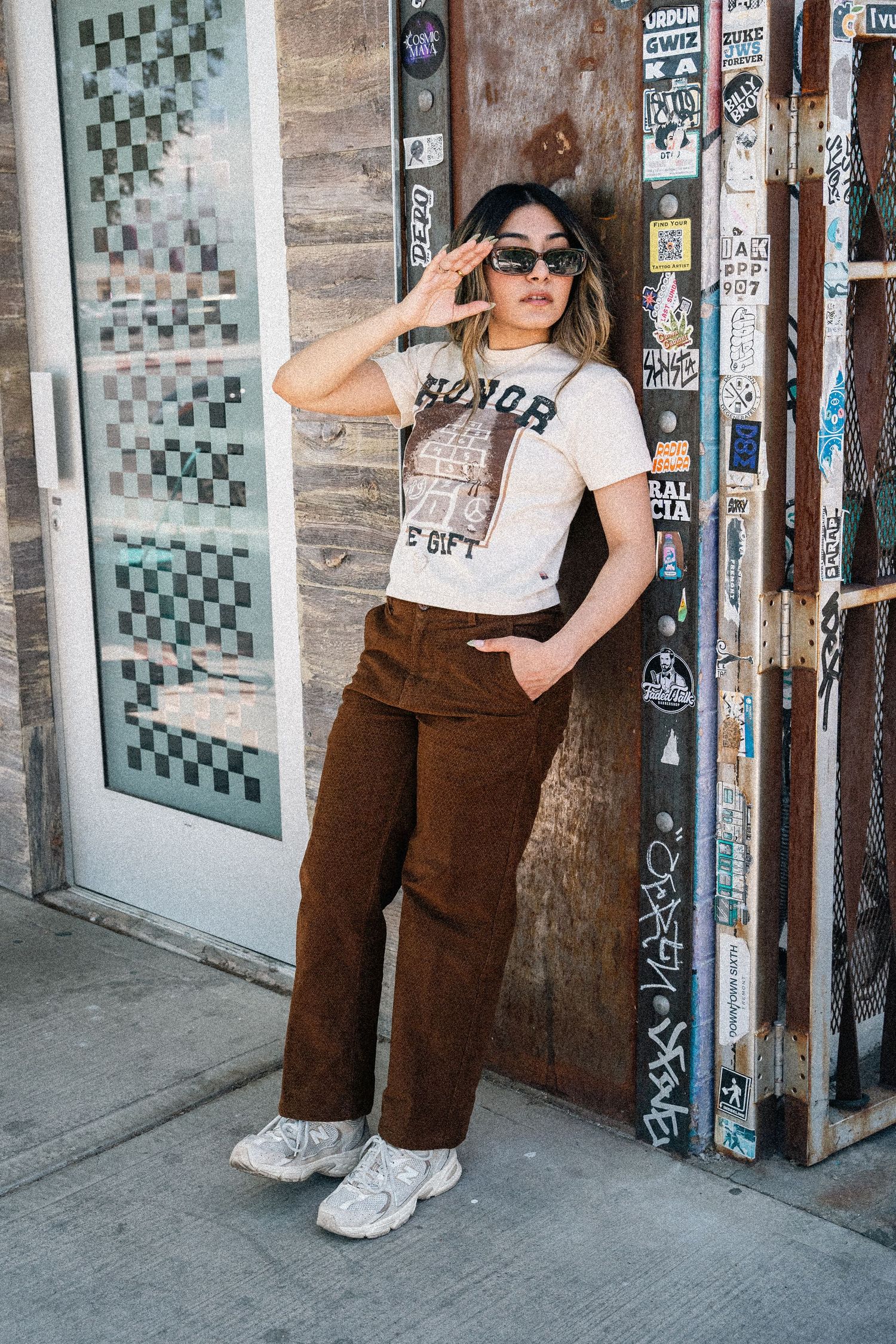 Street style shot showing retro outfit with Honor t-shirt, brown corduroy pants and white sneakers.