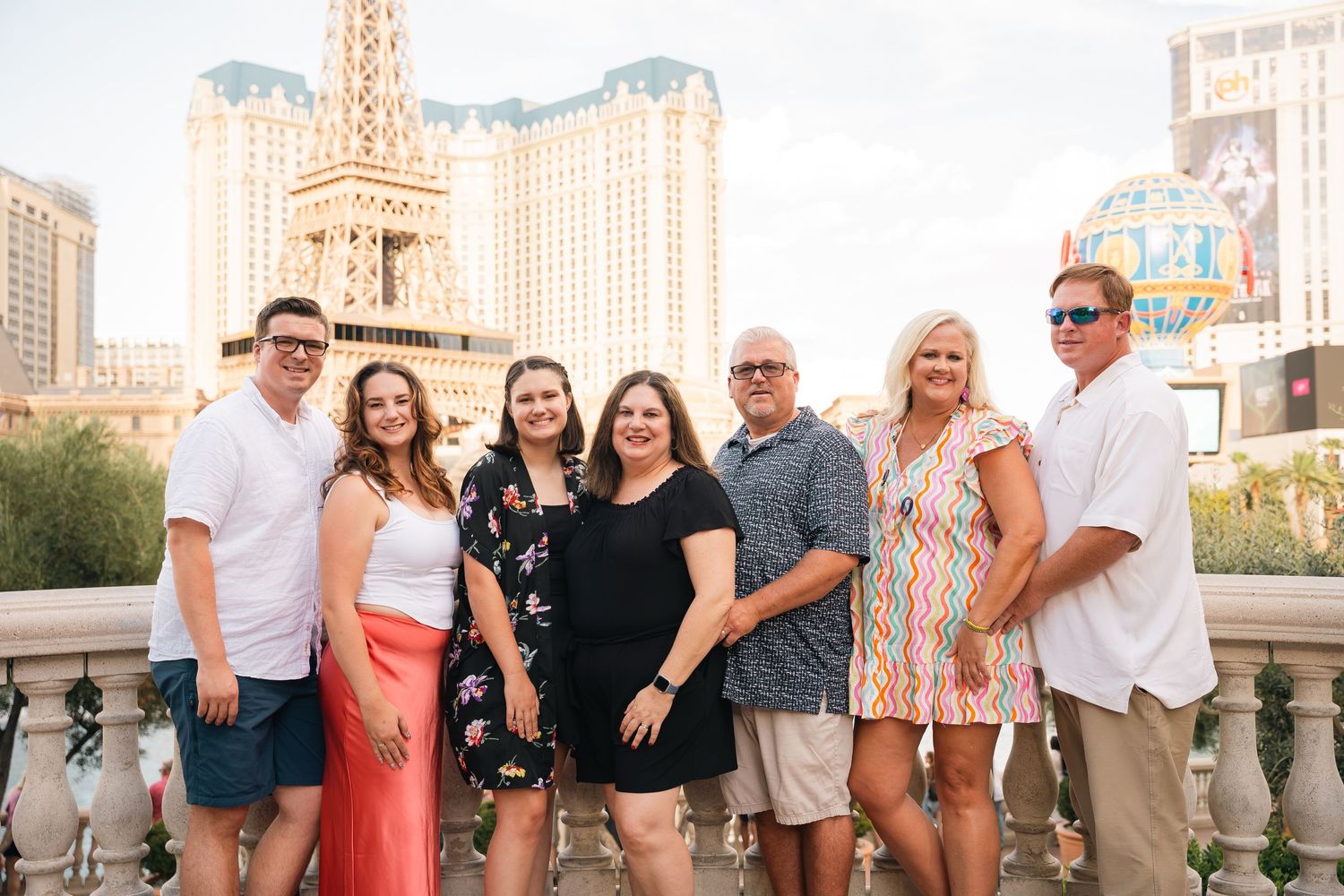 Family group photo on Las Vegas Strip with Paris Hotel Eiffel Tower replica in background.