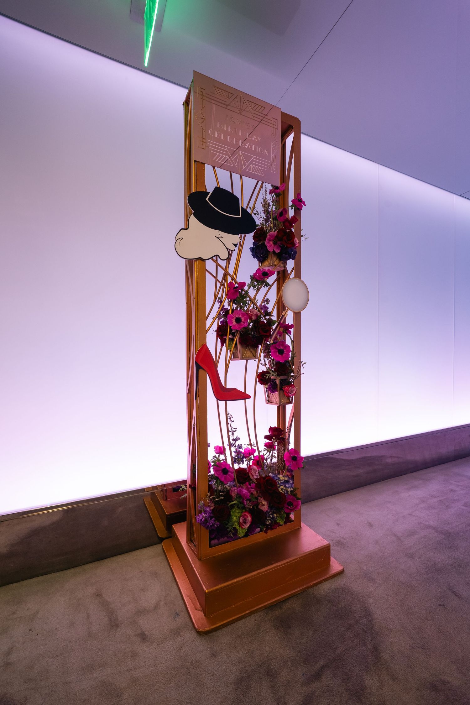 Wooden display stand with purple floral arrangements and mood lighting.