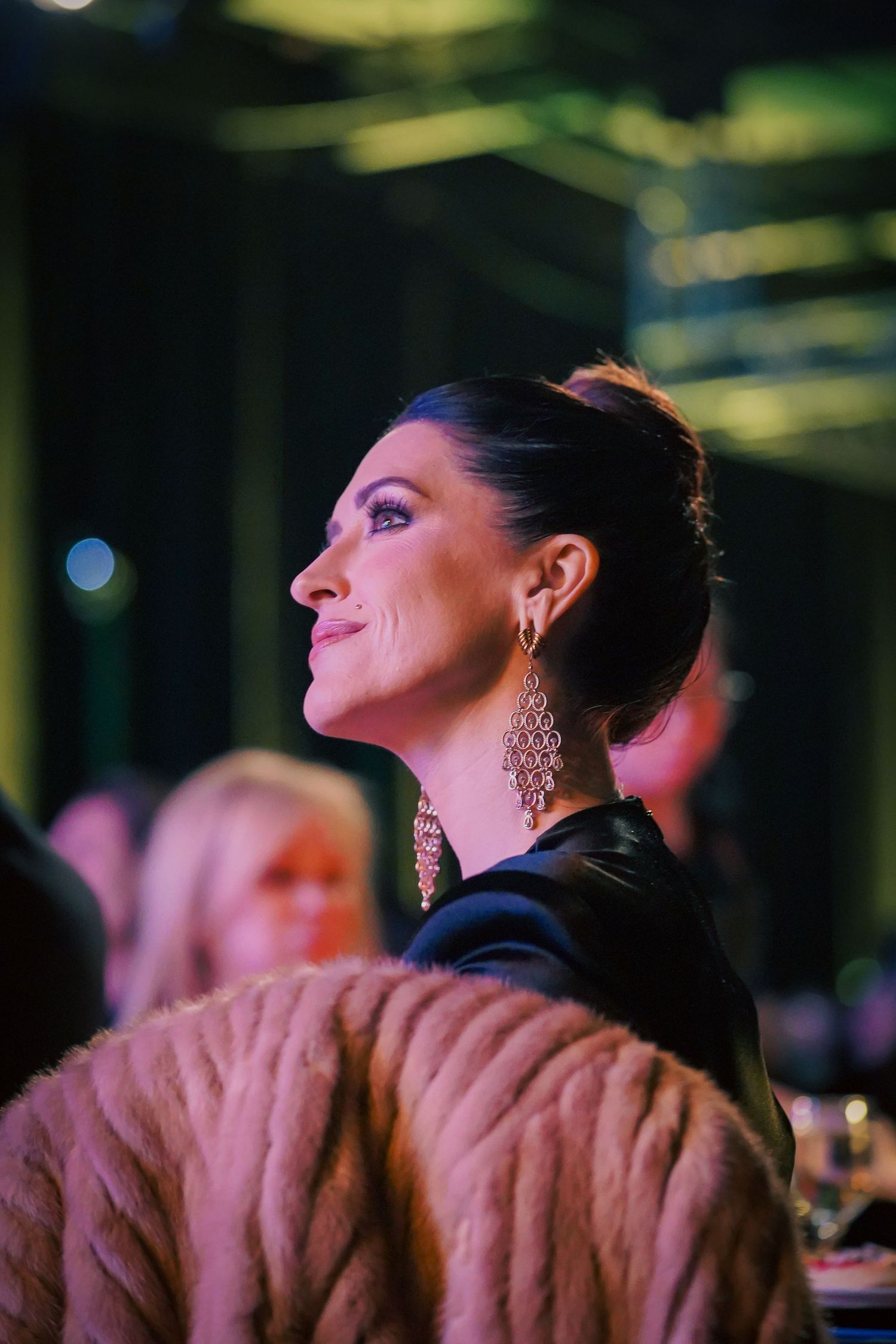 Attendee in formal attire enjoying entertainment at upscale evening event.