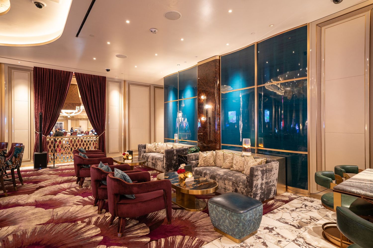 Luxurious lounge area with plush seating and dramatic city views through floor-to-ceiling windows.