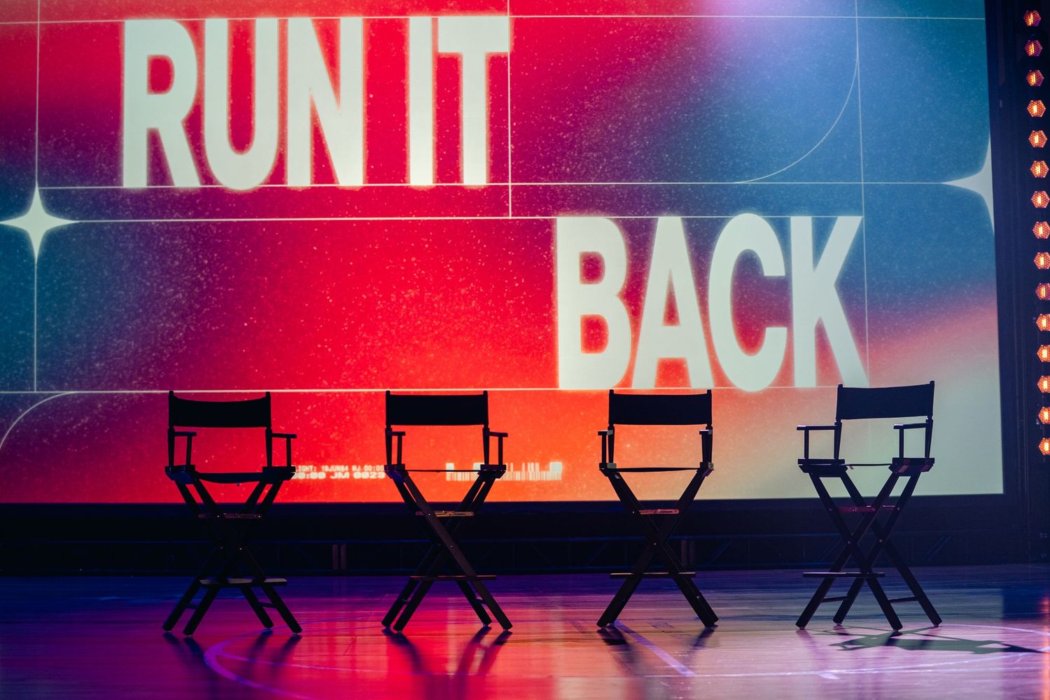 Silhouettes of director chairs against illuminated Run It Back text display.