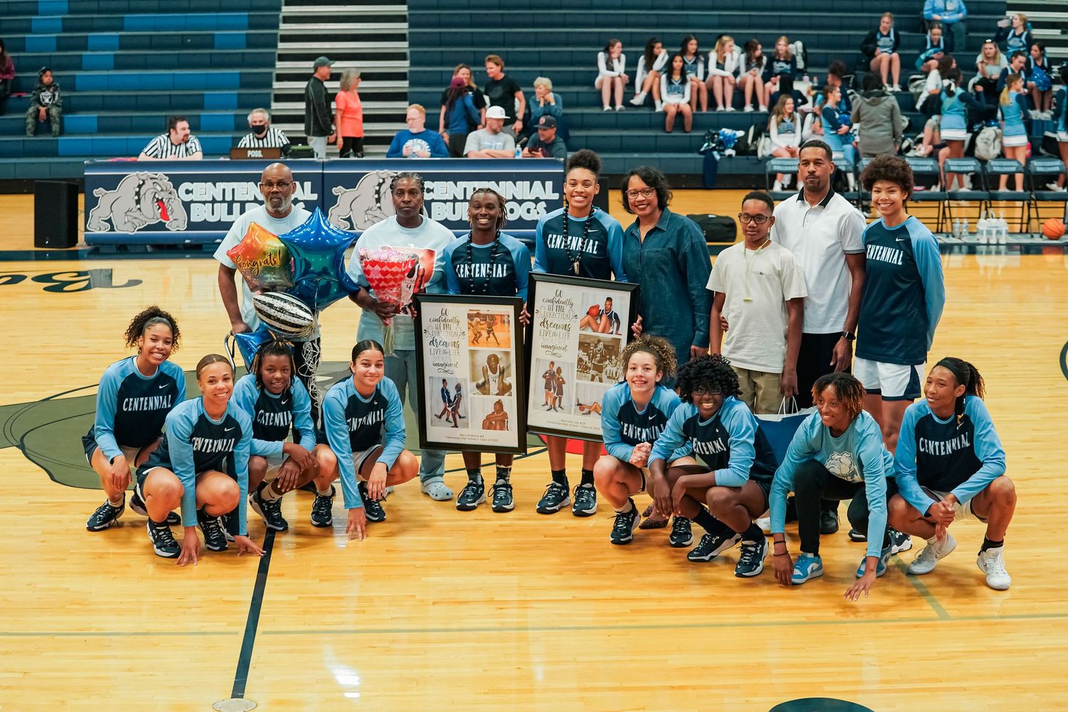 Panoramic view of a gymnasium during a basketball event with players and spectators.