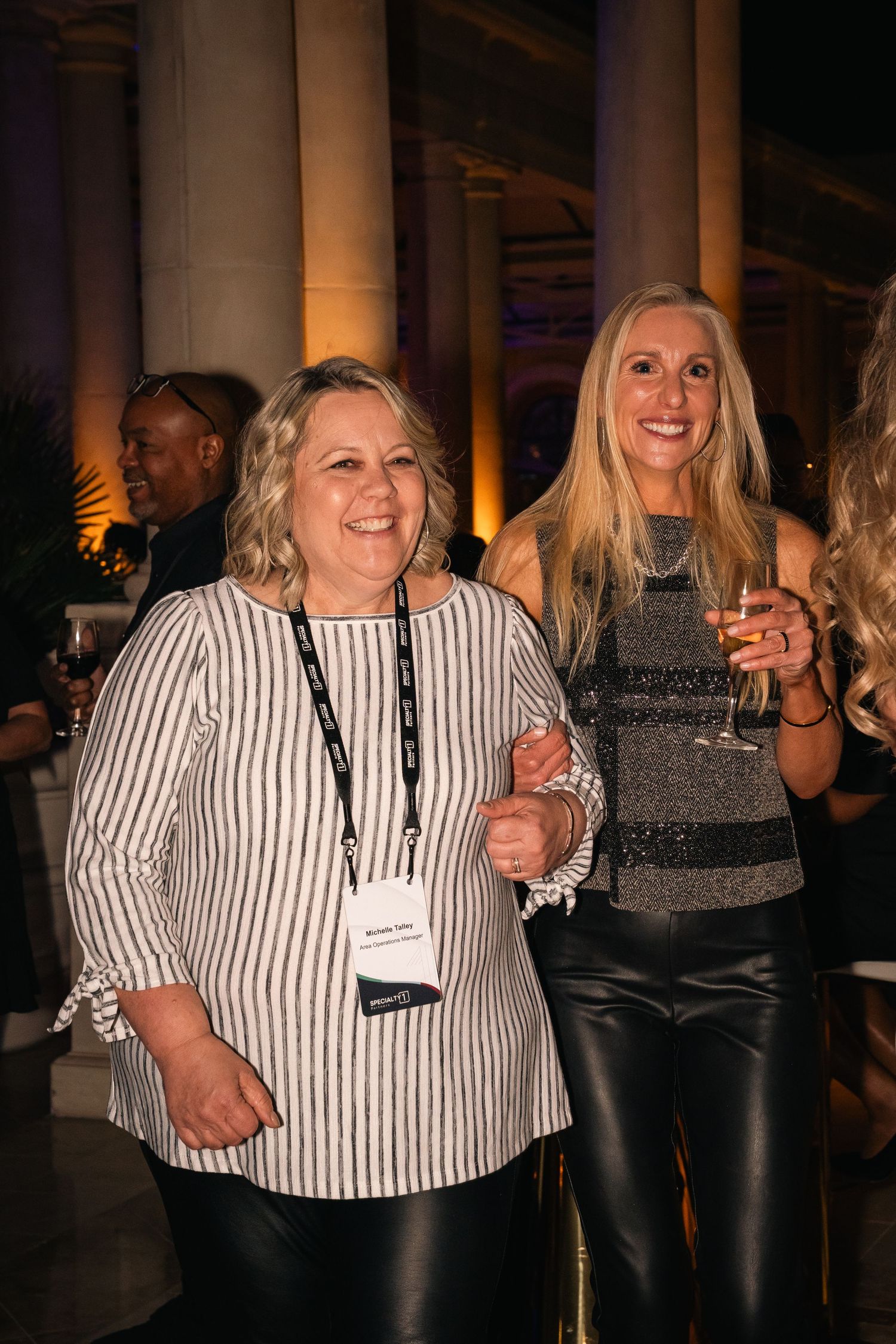 Two attendees in casual attire sharing a moment at networking event.