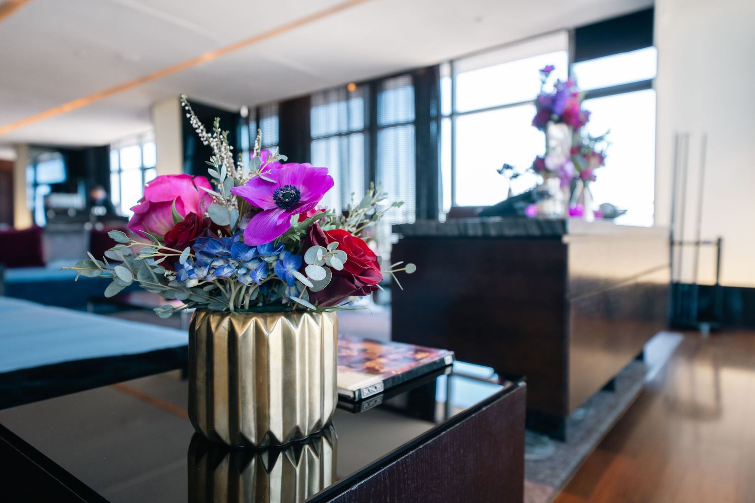 Modern office space with vibrant purple orchid arrangements on sleek tables.