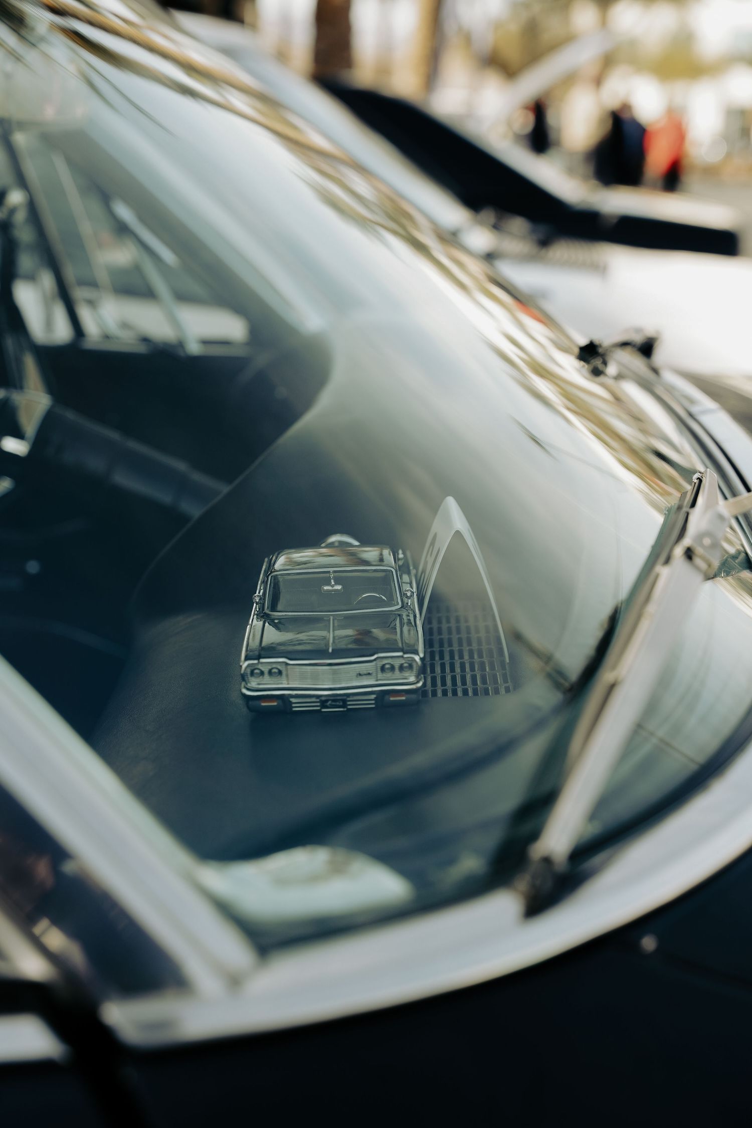 Abstract reflection of classic car silhouette on windshield glass.