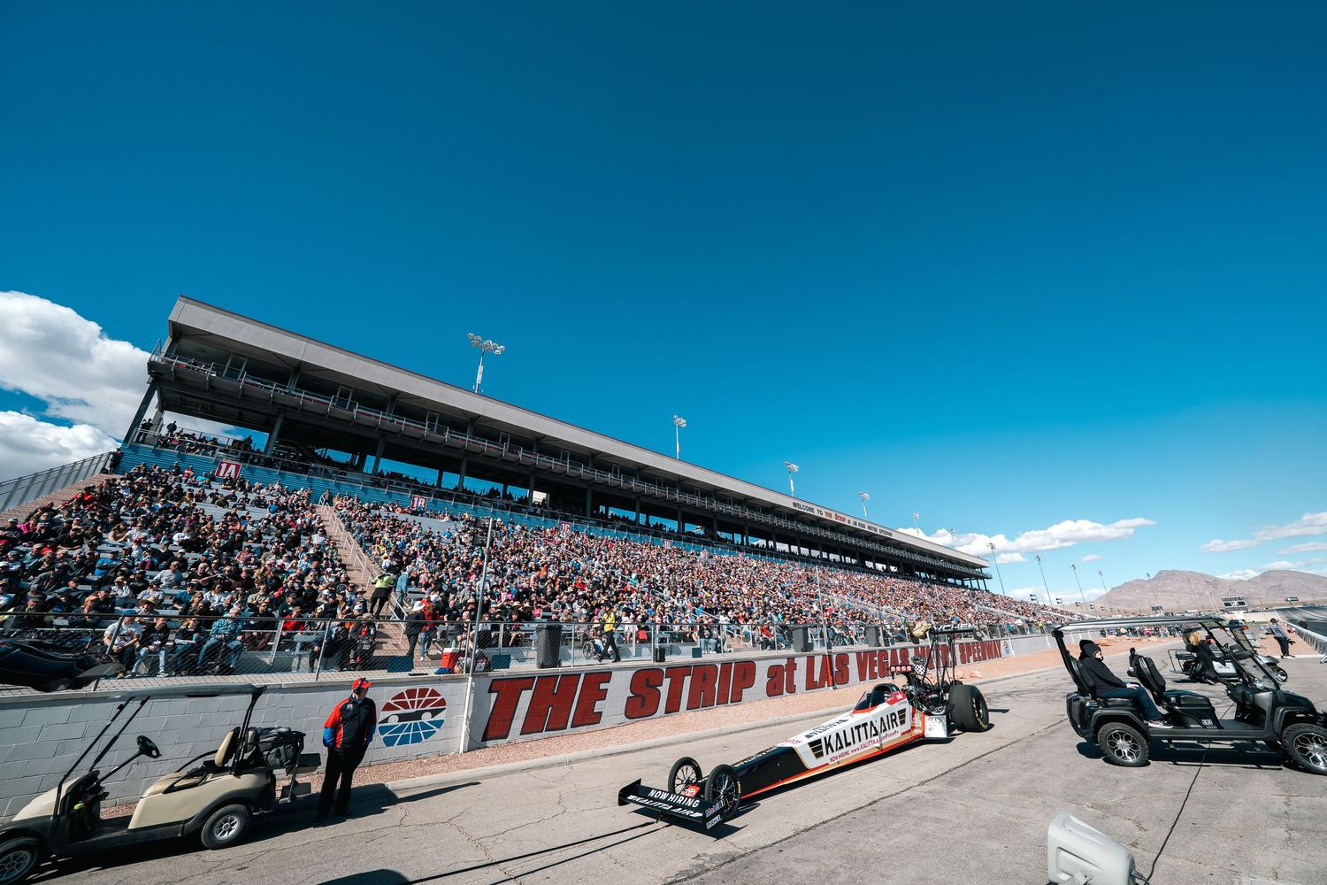 Panoramic view of The Strip at Las Vegas Motor Speedway grandstands filled with spectators.