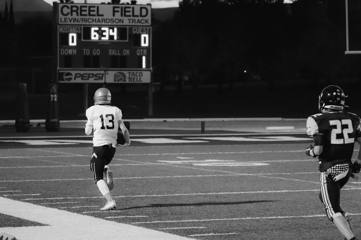 Black and white photo of a nighttime football game at Creel Field.