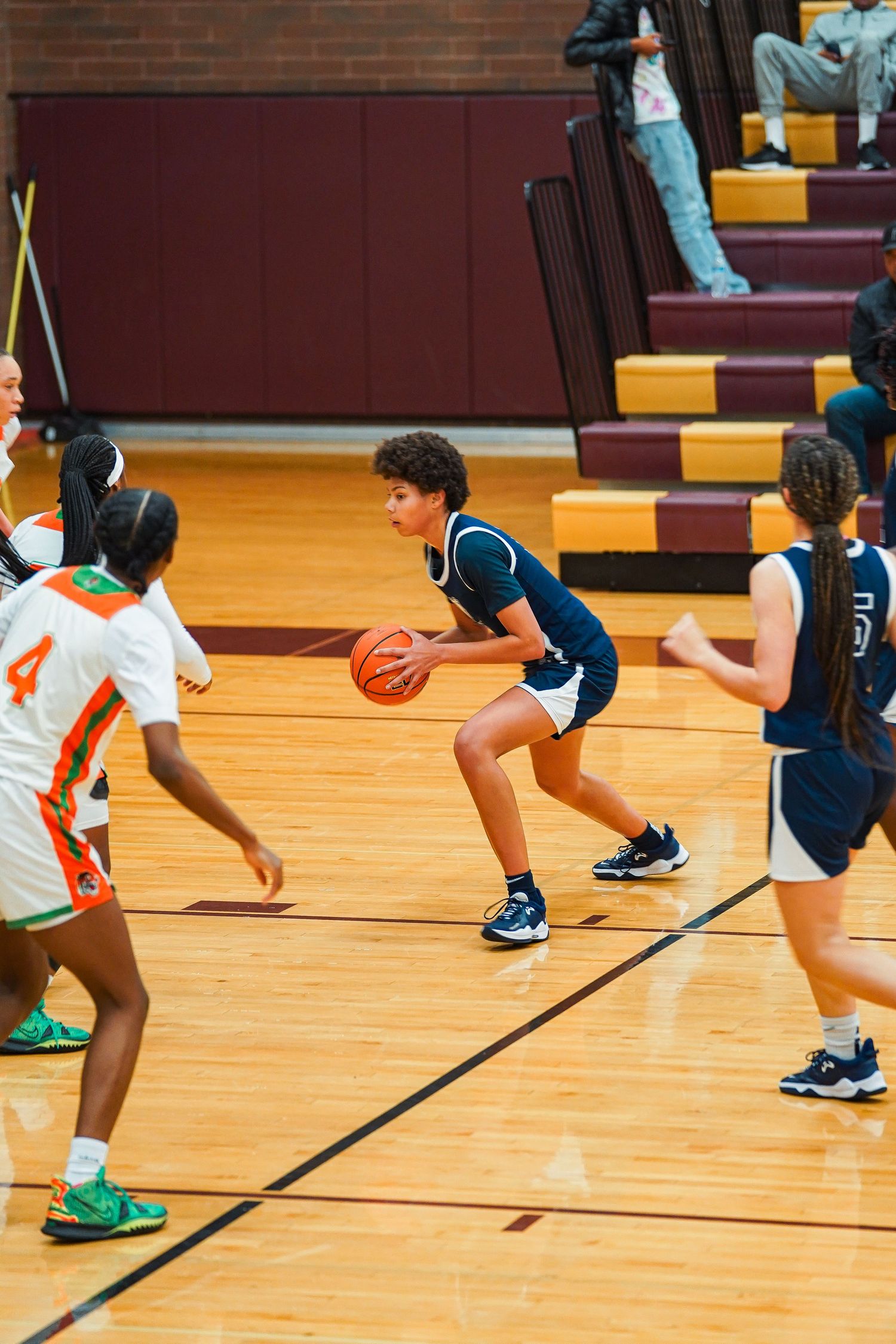 Youth basketball players run drills and exercises across a wooden gymnasium floor.