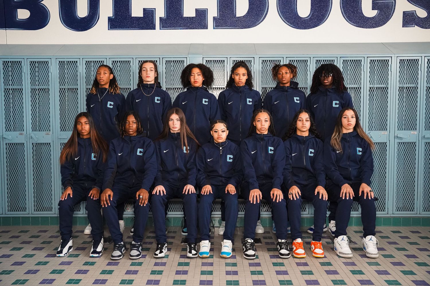 Centennial Bulldogs women's basketball team poses in navy warm-up gear for official team photo.