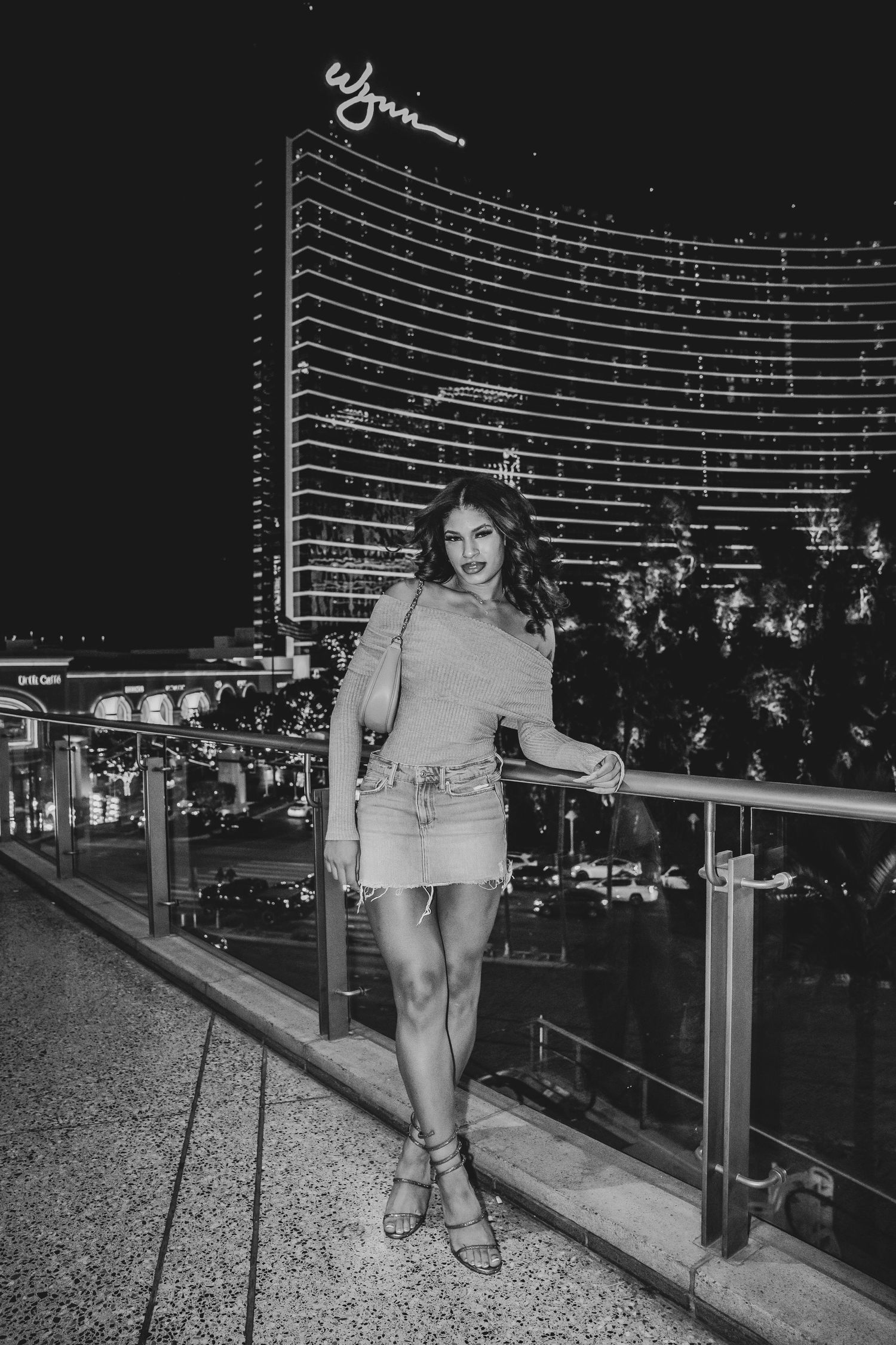 Black and white fashion photo at Las Vegas hotel with city lights backdrop.