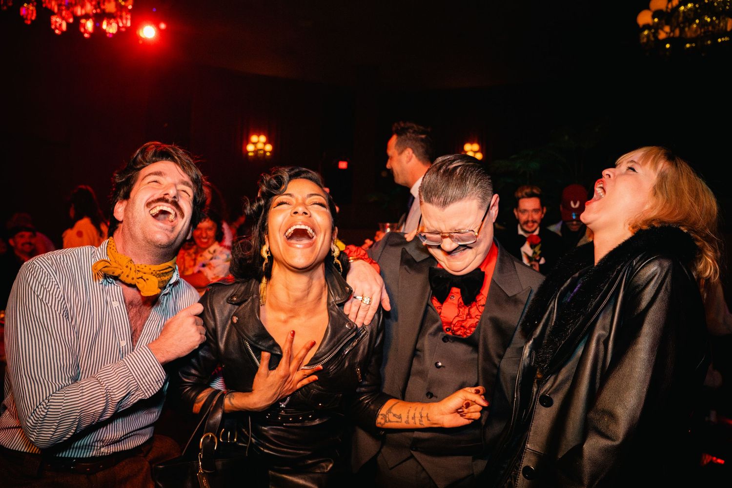 Group of people laughing joyfully at nighttime entertainment event.
