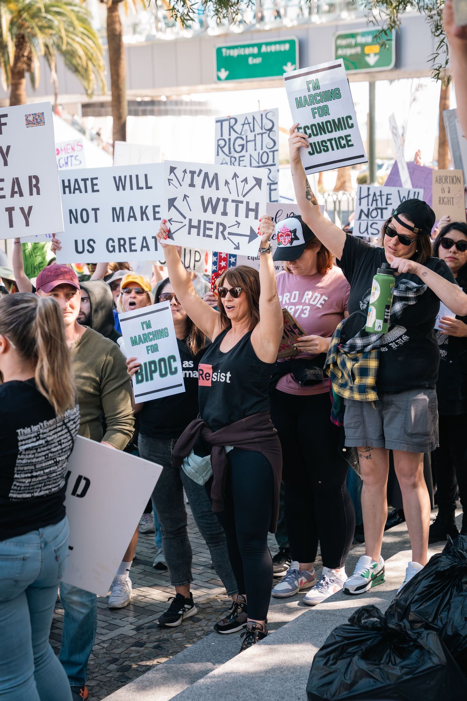 Protesters hold signs about trans rights and equality during street demonstration.