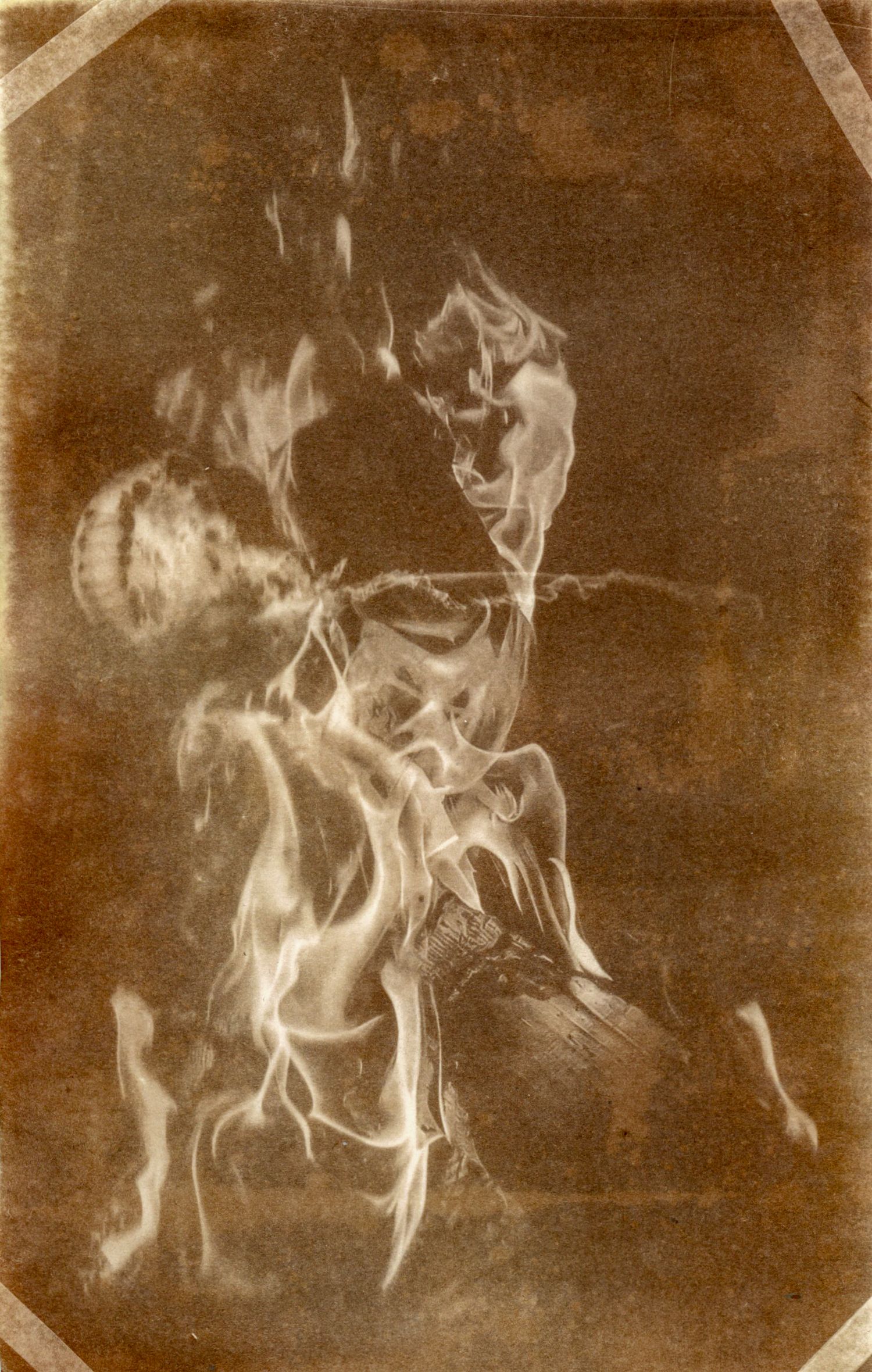 Abstract sepia photograph showing swirling smoke or flame patterns.