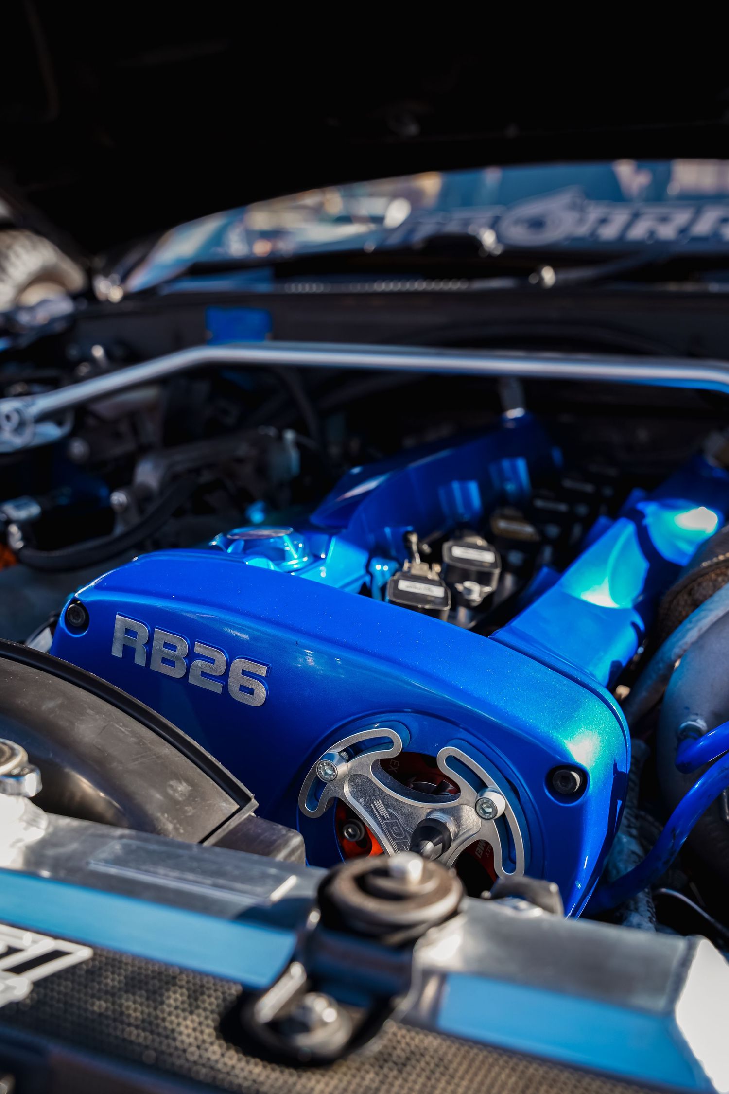 Blue RB26 engine bay with performance modifications and custom components.