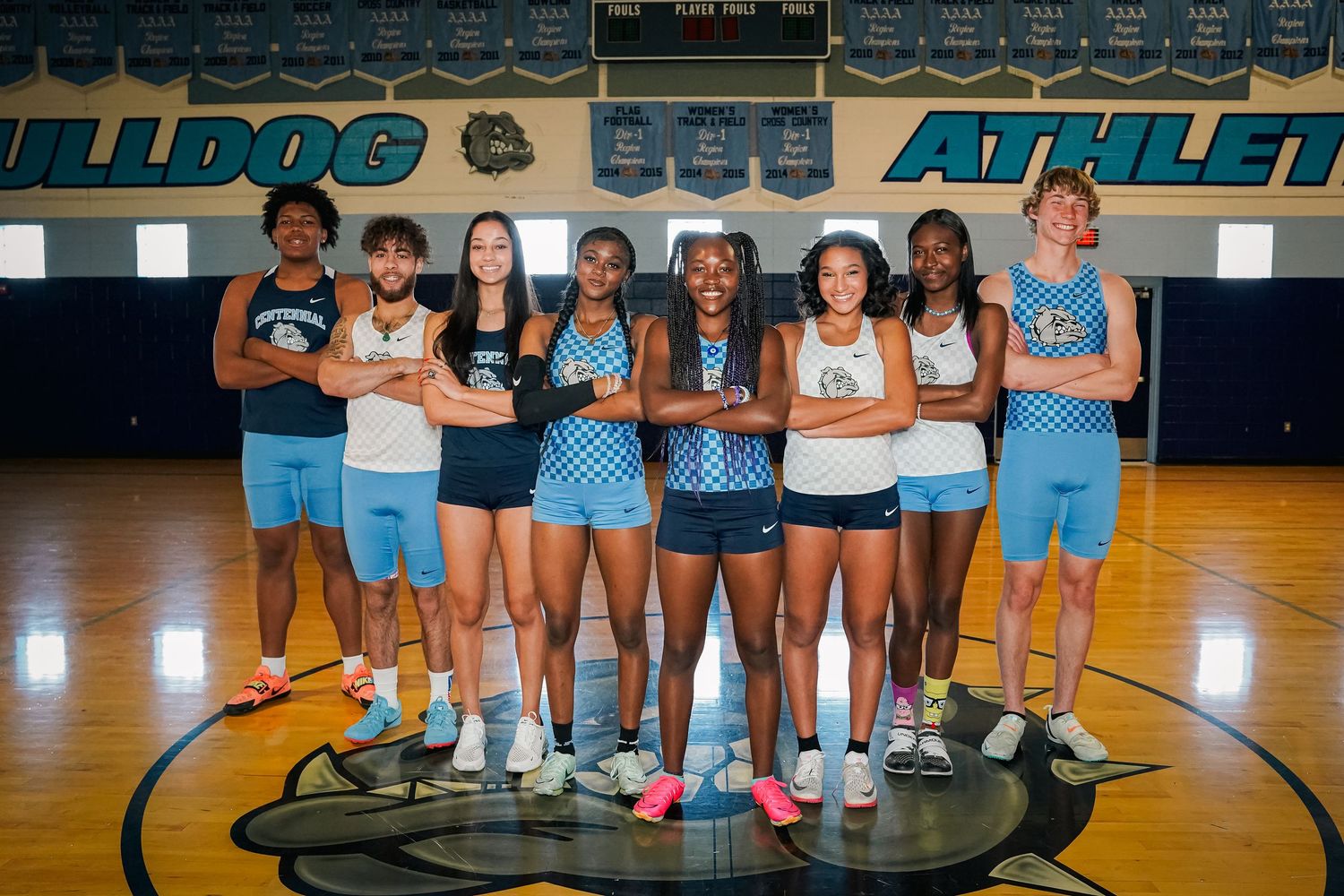High school basketball team posed together on court in blue and white uniforms.