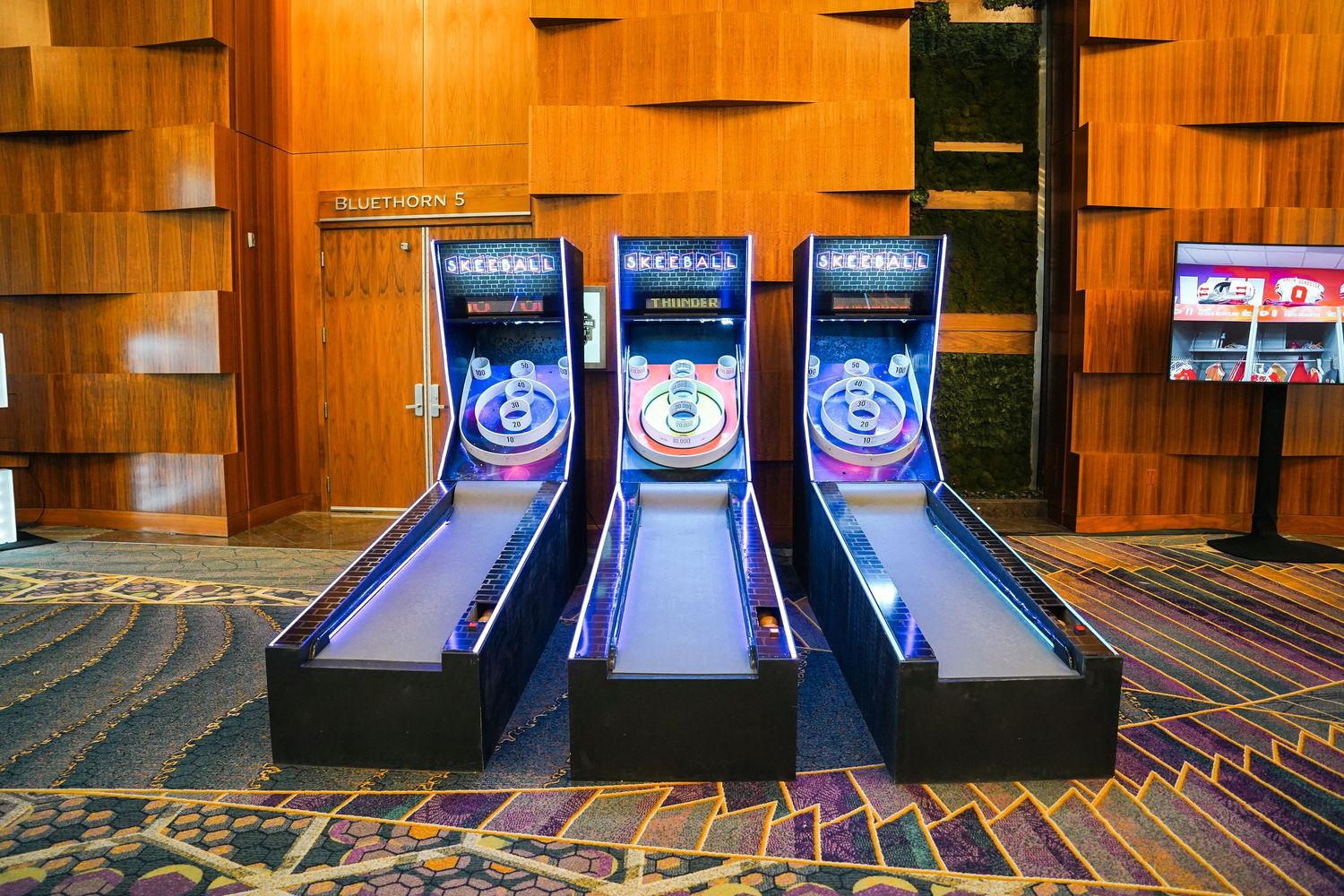 Professional bowling lanes with blue LED lighting and digital scoring displays.