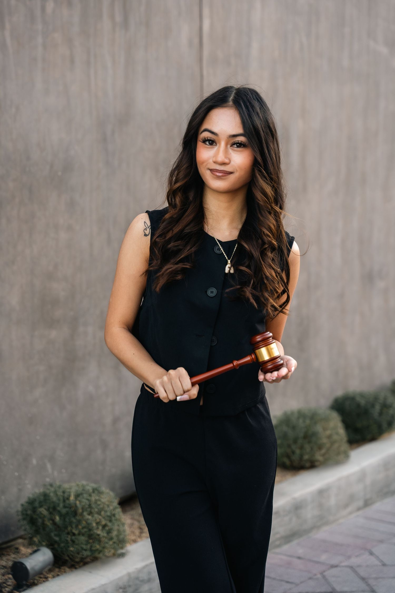 Professional portrait with black outfit holding a ceremonial gavel.